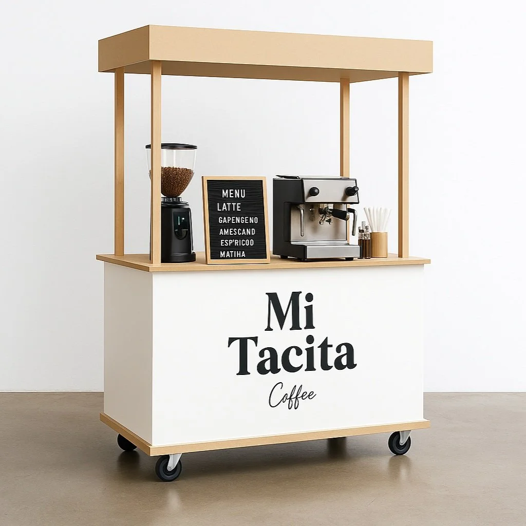 Coffee cart with a sign that reads "Mi Tacita Coffee," featuring a coffee grinder, an espresso machine, a menu board, and stir sticks.