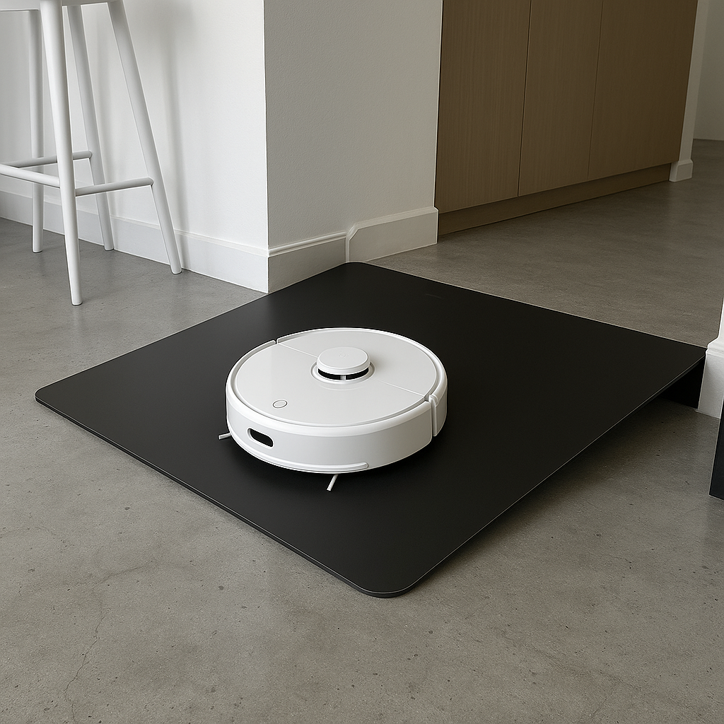 A robotic vacuum cleaner on a black mat in a modern kitchen or living space.