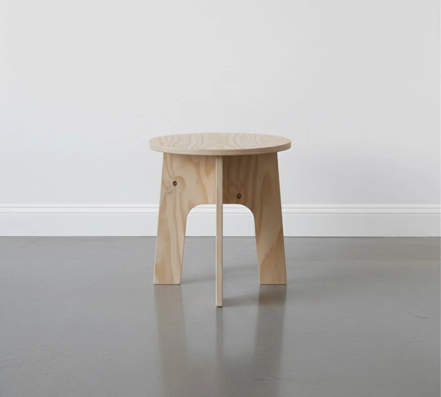 Premium grade birch plywood outdoor collapsible stool in a well lit studio with white wall and concrete floor