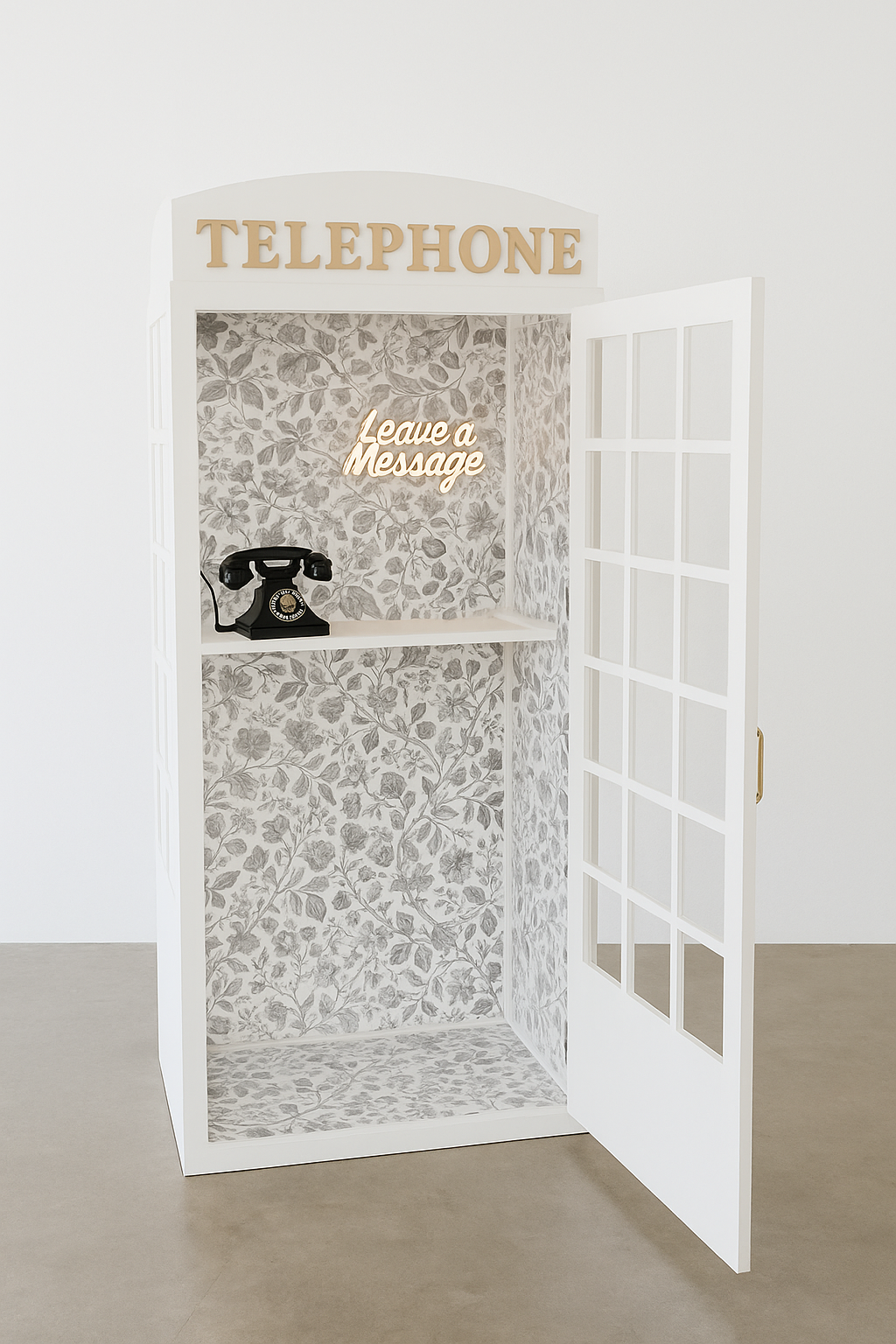 White collapsible telephone booth hire with vintage rotary phone, floral wallpaper, brass handle, mirrored ceiling, tiled base, and 'Leave a Message' LED sign—perfect for weddings, parties, and audio guestbooks in Melbourne.
