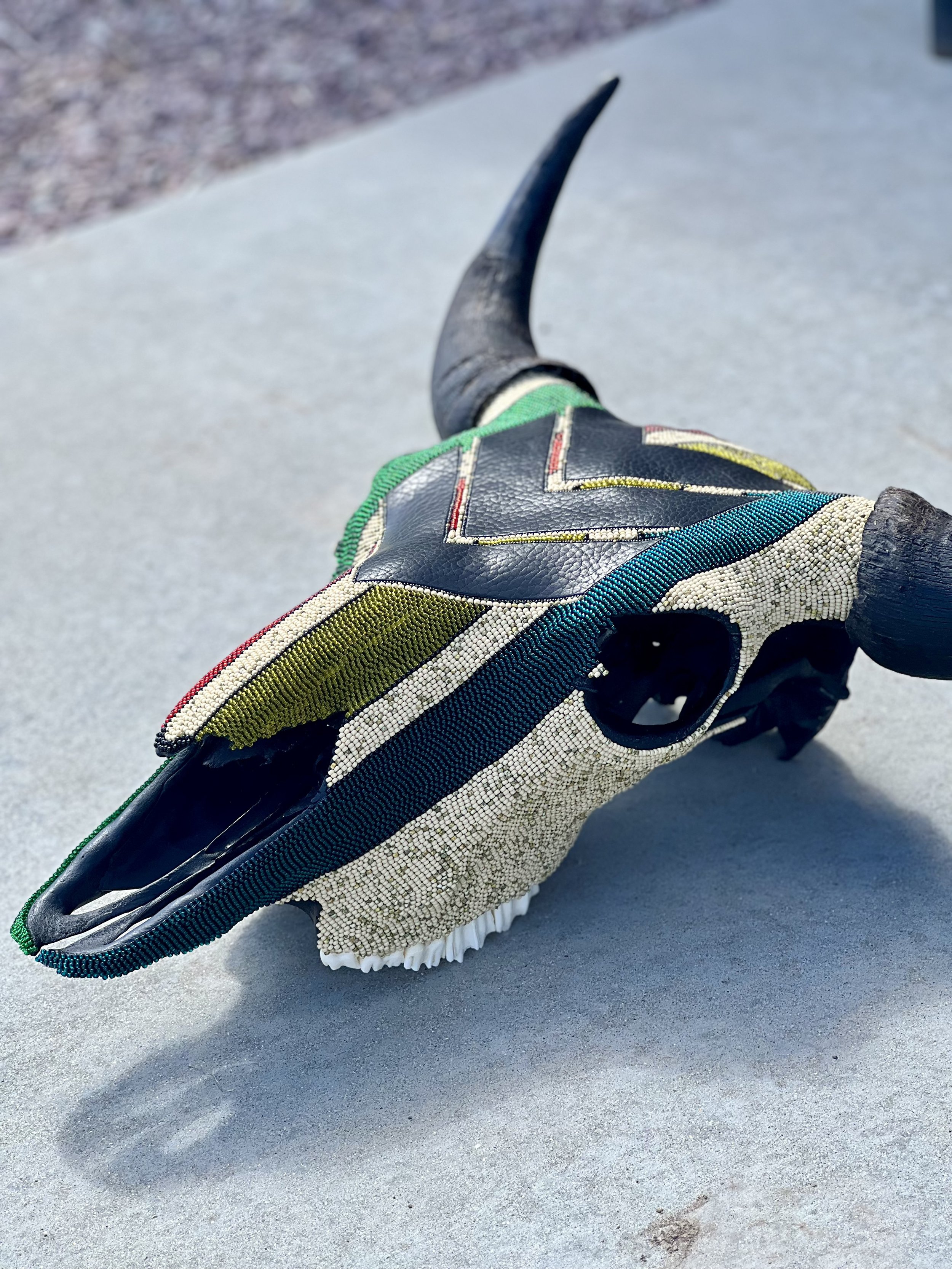 Bison skull adorned in colorful beads and genuine bison leather segments.