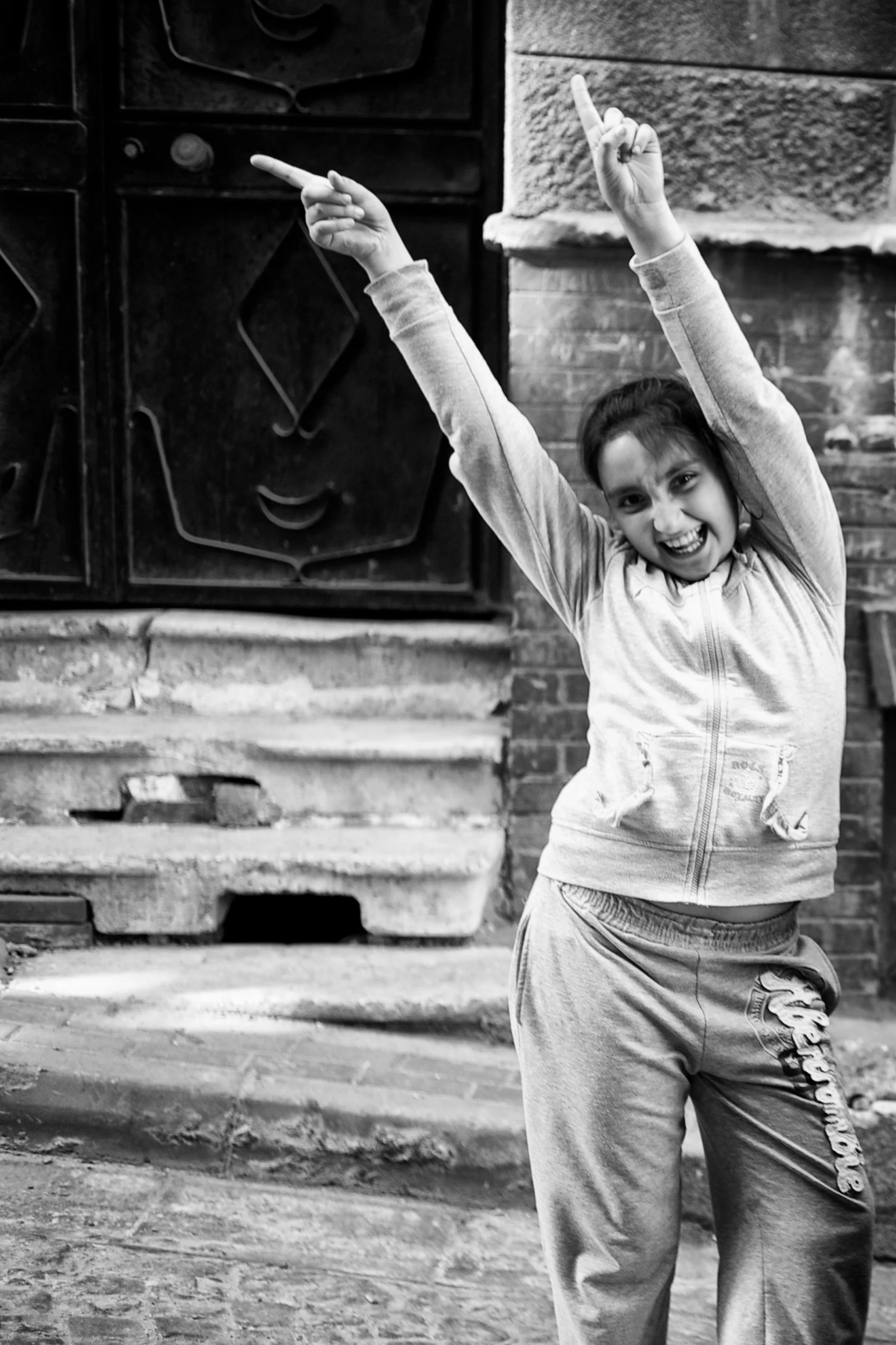 Ein lachendes Mädchen in sportlicher Kleidung, das in die Luft zeigt.