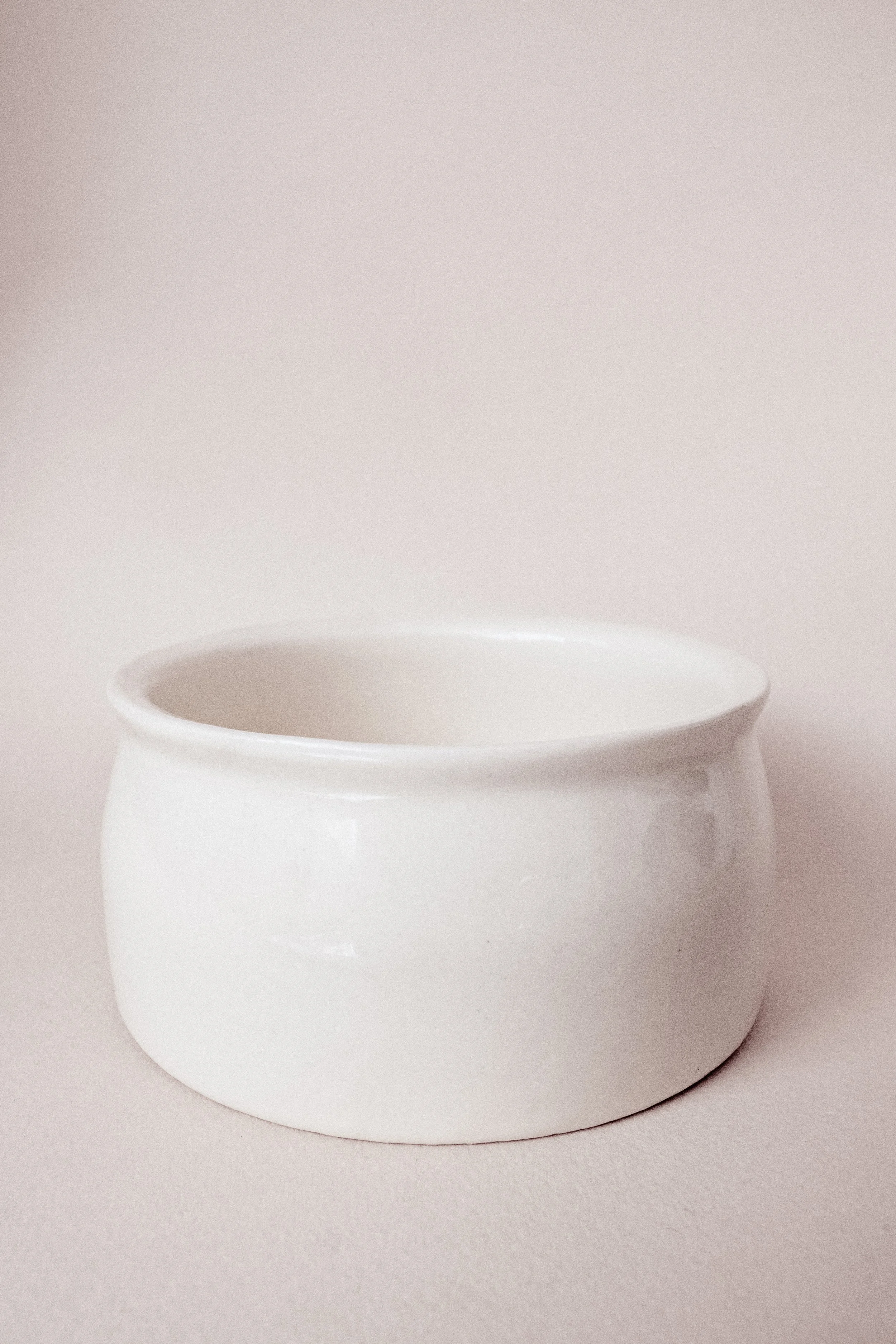 Ein weißer Keramiktopf auf einem hellen Hintergrund.