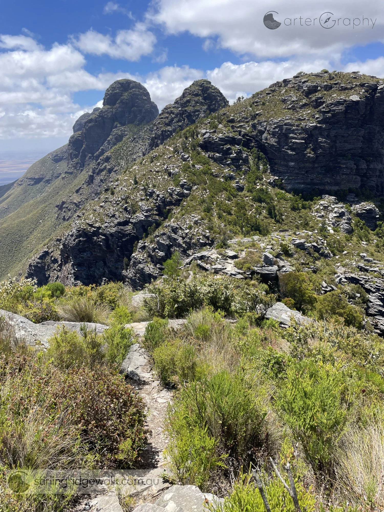 Looking east while ascending towards 1st Arrow. The tracks can be seen descending the north west flank of 2nd Arrow in the foreground, with 3rd Arrow beyond and Pyungoorup Peak forming the distant backdrop.