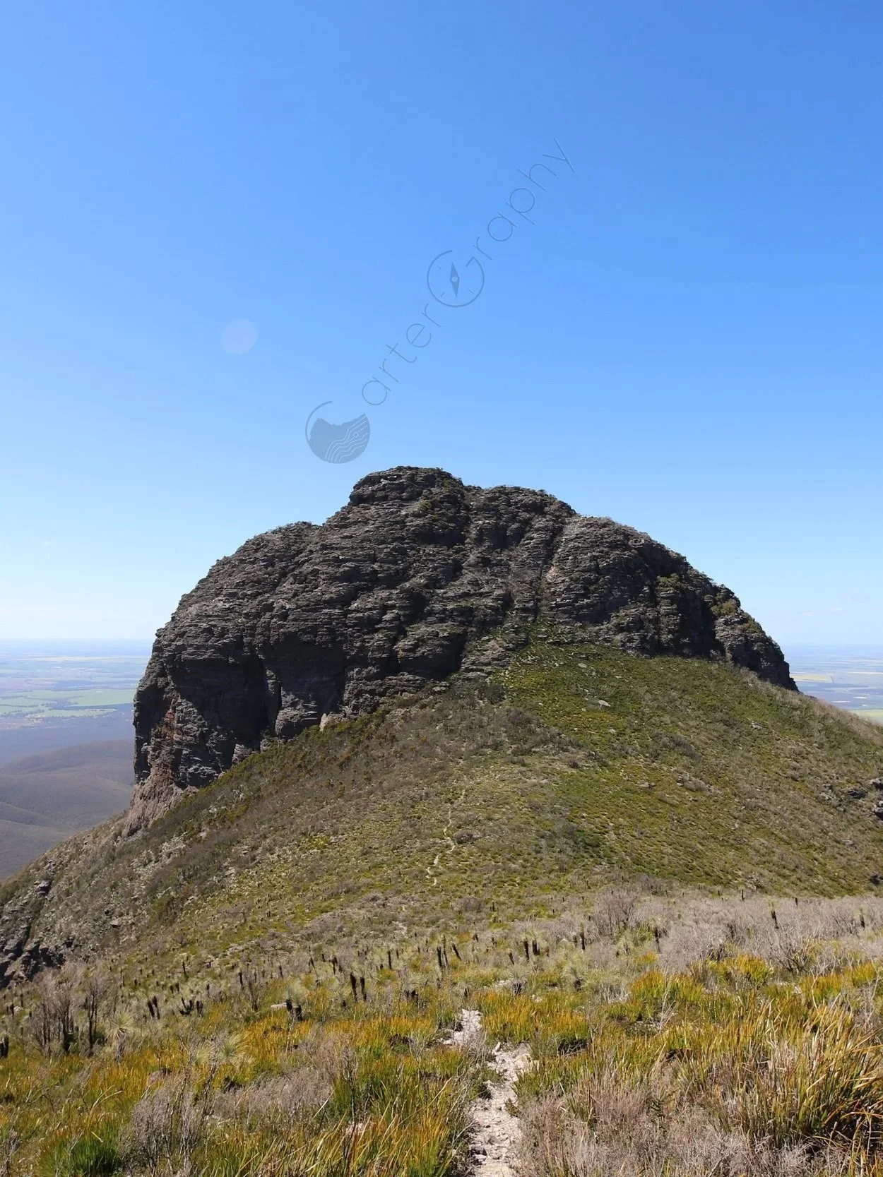 Looking down from beside the yellow ground marker towards the saddle between Ellen Peak and Pyungoorup Peak. The track ascends from the saddle towards Ellen Peak, where it branches between the route up and over Ellen Peak summit and the northerly tra