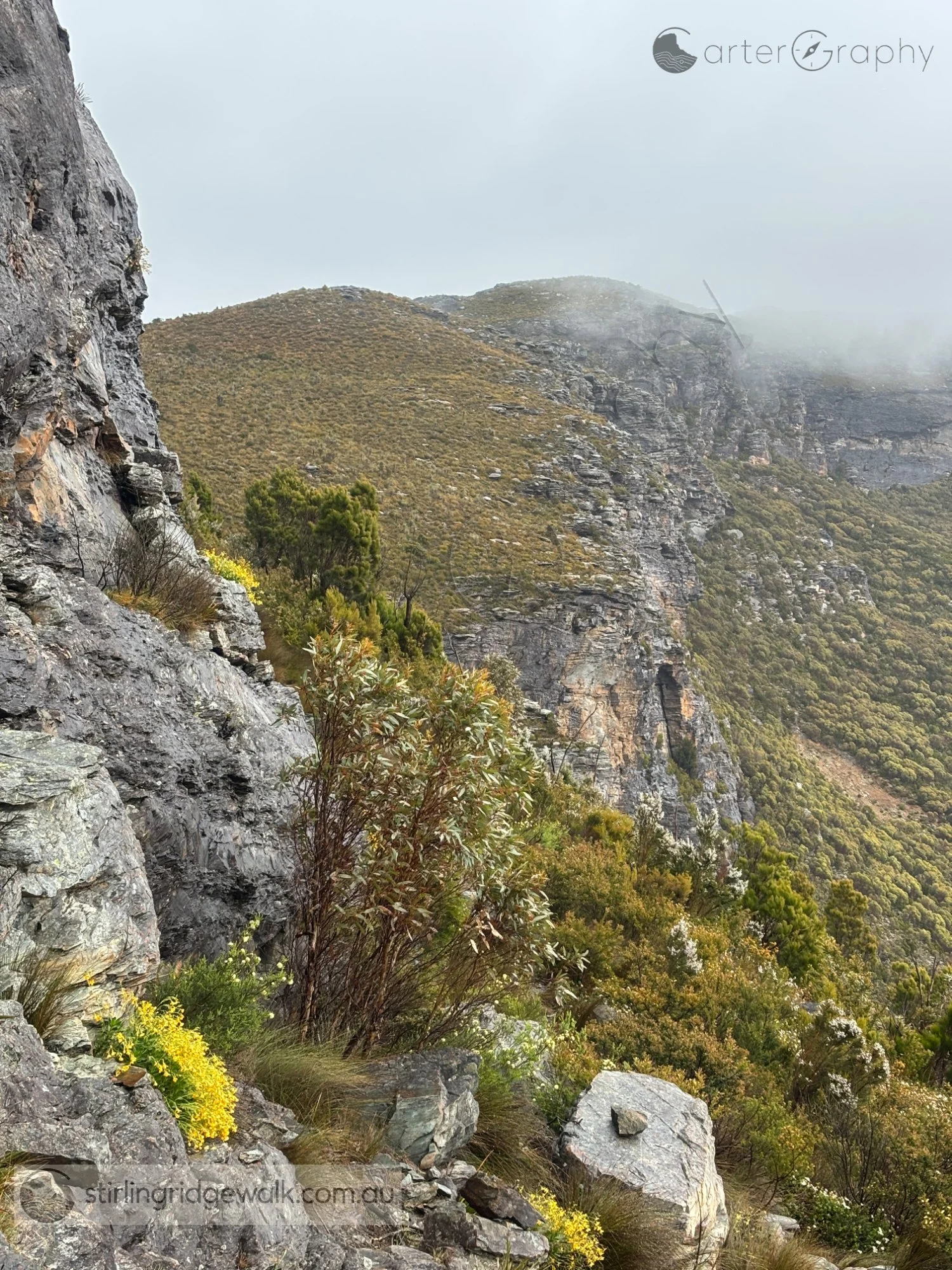 Traversing around the northern base of Ellen Peak, with the track following the steep rock face towards the saddle between Ellen Peak and Pyungoorup Peak as low cloud drifts across the Ridge.