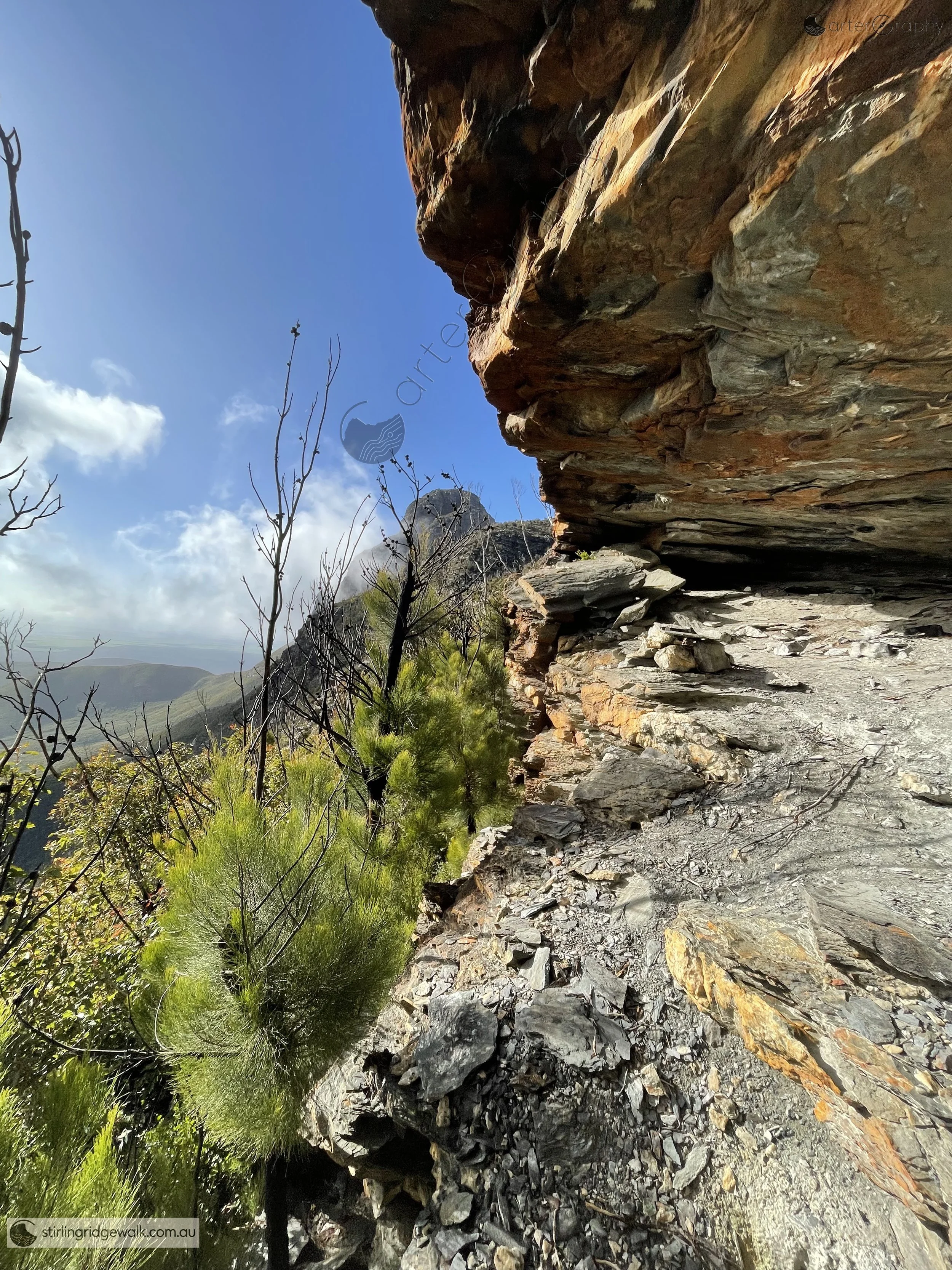 The small cave beneath the northern face of East Pinnacle, with Pyungoorup Peak visible in the background.