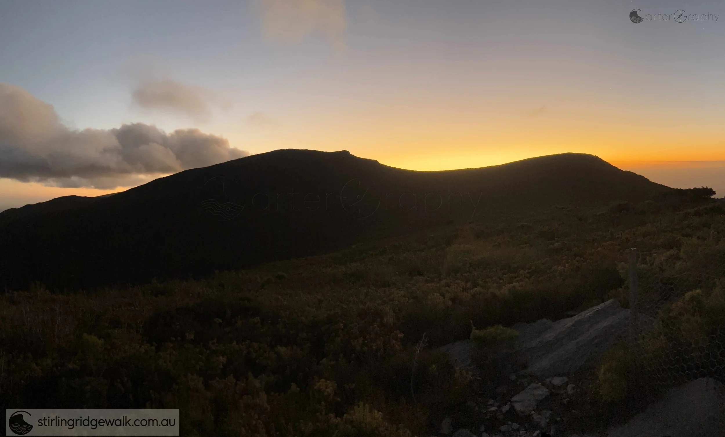 A beautiful sunset silhouettes the three peaks of the Isongerup massif: Isongerup South Peak on the left, Isongerup Main Peak in the centre, and Isongerup North Peak on the right.