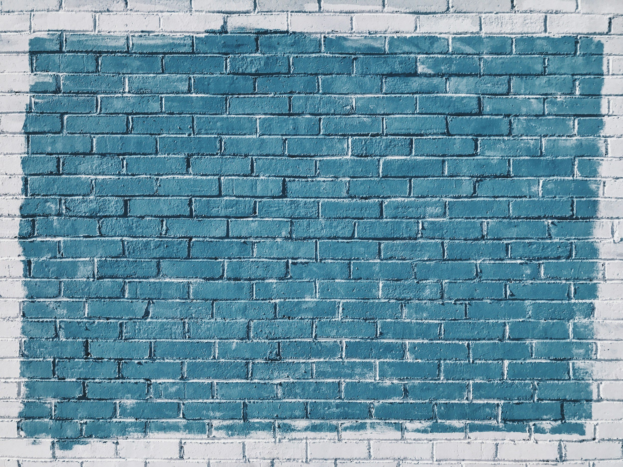 Brick wall painted with a large blue rectangle.