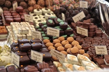 Assorted chocolates and cookies displayed on a table with labels.