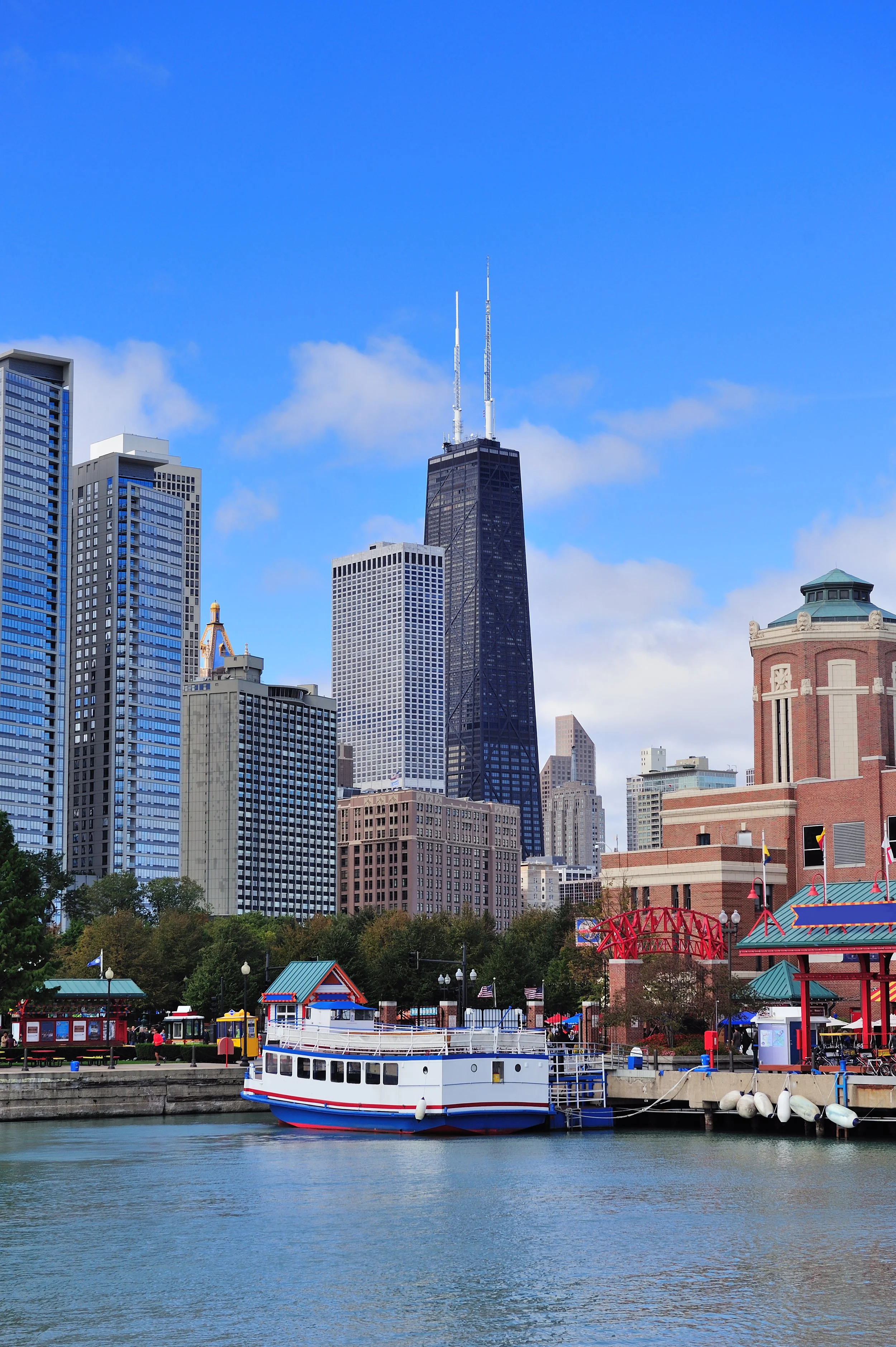 Chicago skyline with John Hancock Center and boat docked at pier in foreground.