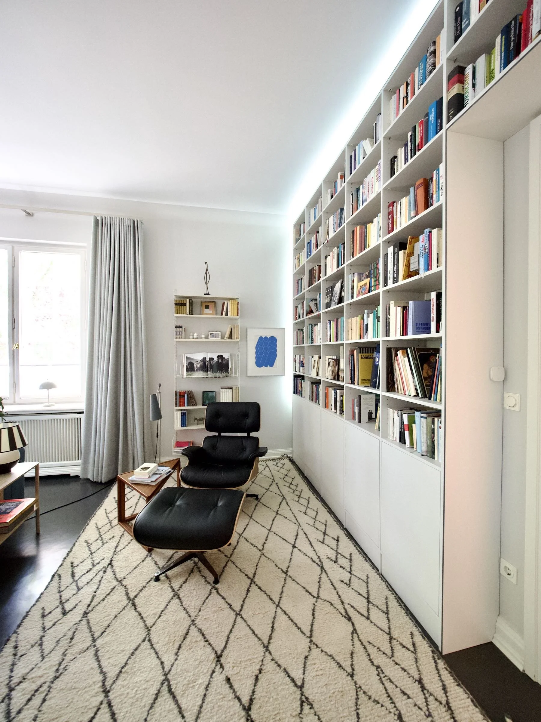 Ausgangssituation: ein großer unmöblierter Raum mit schwierigen Lichtverhältnissen
Wunsch: ein gemütliches Wohnzimmer mit viel Platz für alle Bücher
Umsetzung: Farb- und Möblierungskonzept mit raumhohem Bücherregal