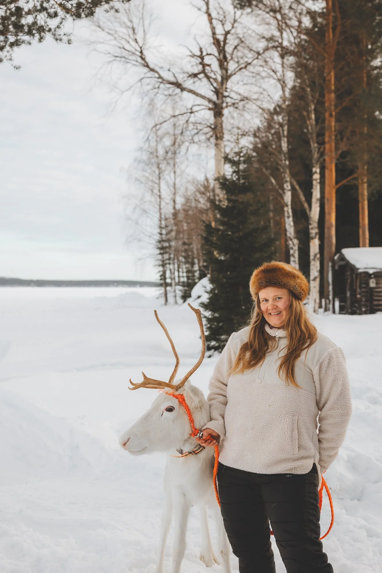 Opas Kristiina vierellään valkoinen poro.