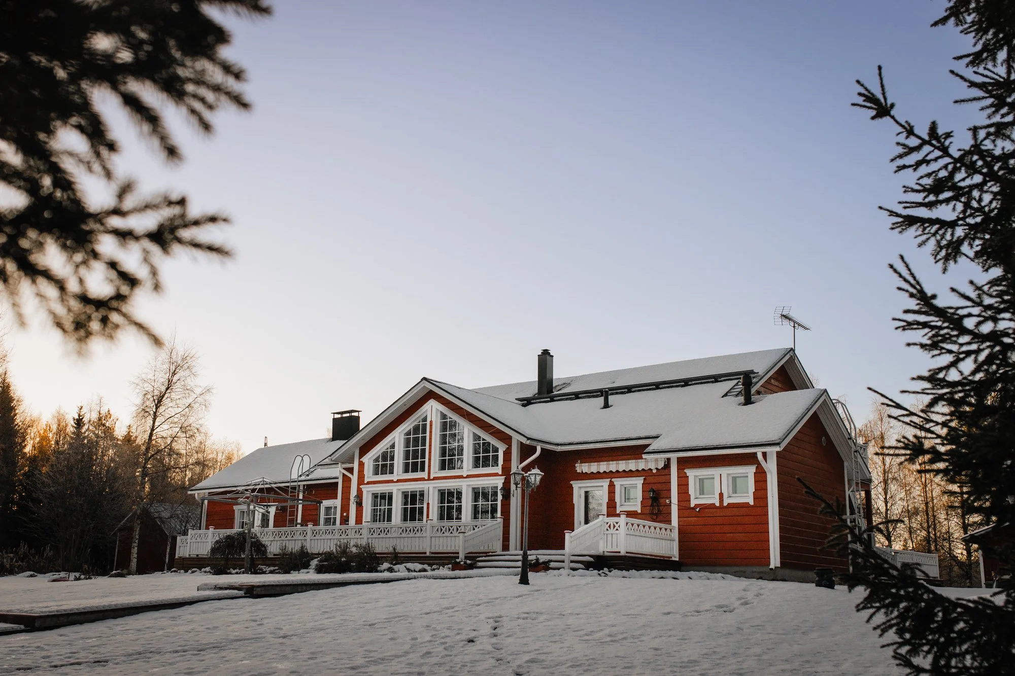 Suuri punavalkoinen huvila ulkoapäin kuvattuna Rovaniemen Norvajärvellä.