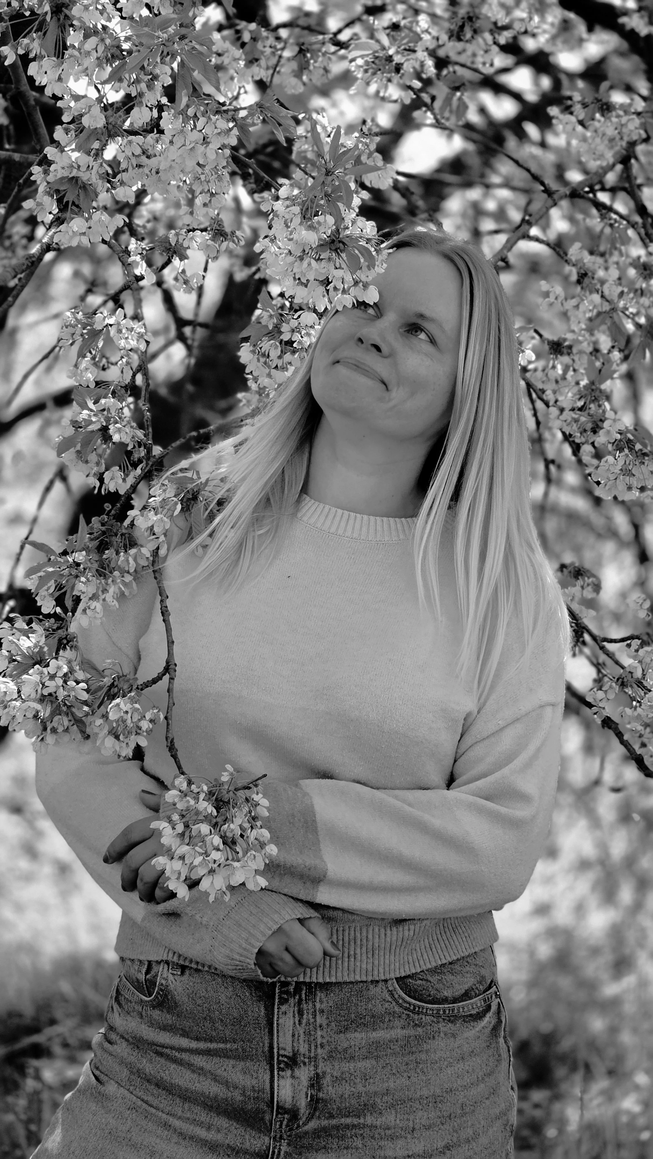 Saskia zwischen blühenden Bäumen – natürliches Schwarz-Weiß-Portrait in der Lüneburger Heide.