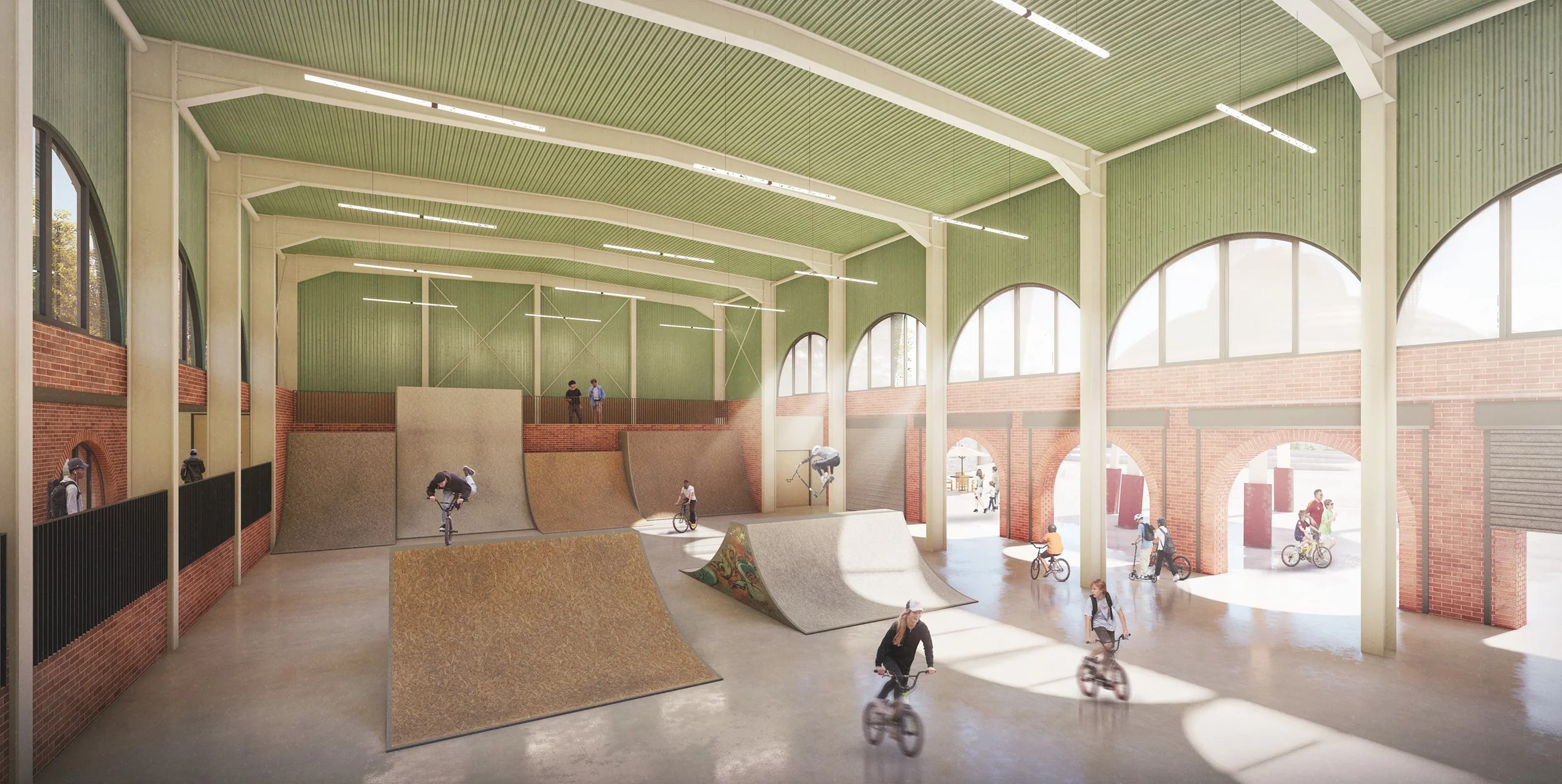 Indoor skate park with ramps, half-pipes, and a green ceiling, populated with people riding bikes and skateboards, surrounded by large windows and brick walls.