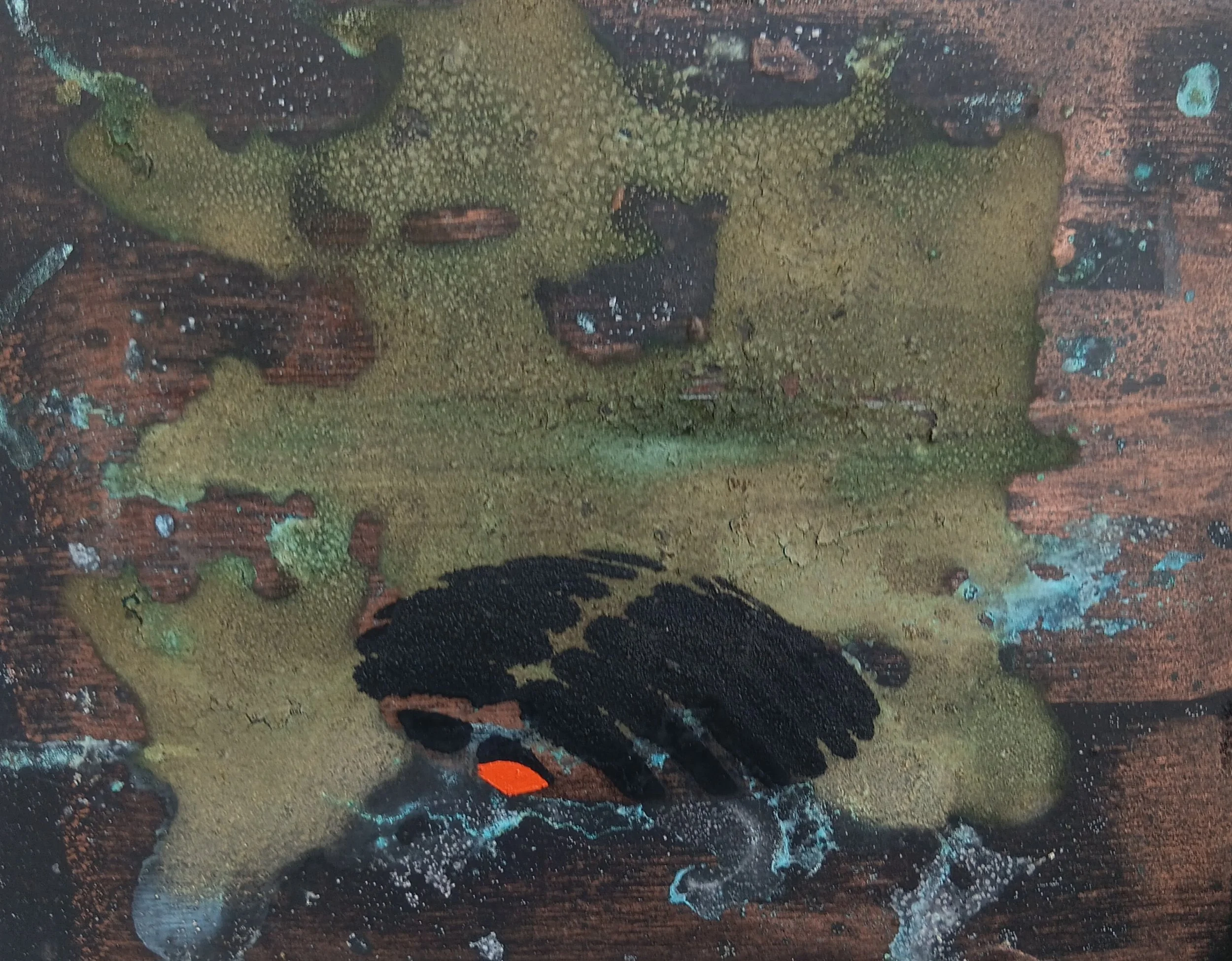 A close-up view of a colorful abstract painting on a wooden surface, featuring green, black, orange, and blue paints mixed with textures and splatters.