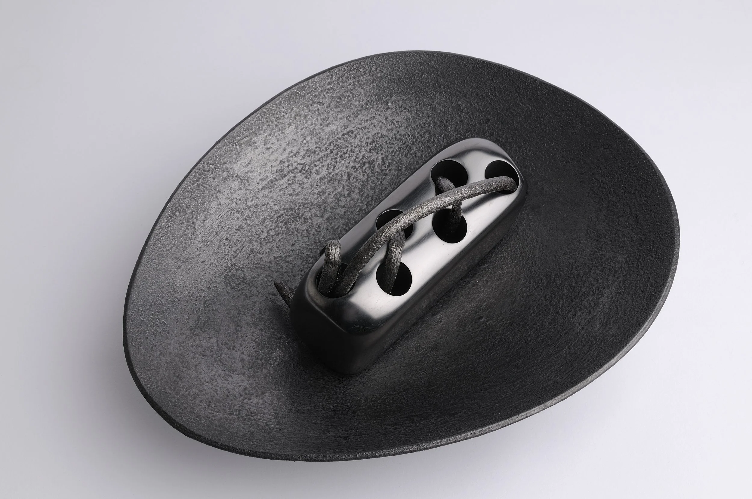 Close-up of a black leather belt buckle with the strap threaded through it, on a plain white background.