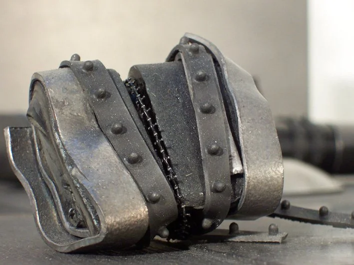 Close-up of a damaged metallic pipe coupling with a crack and broken parts.
