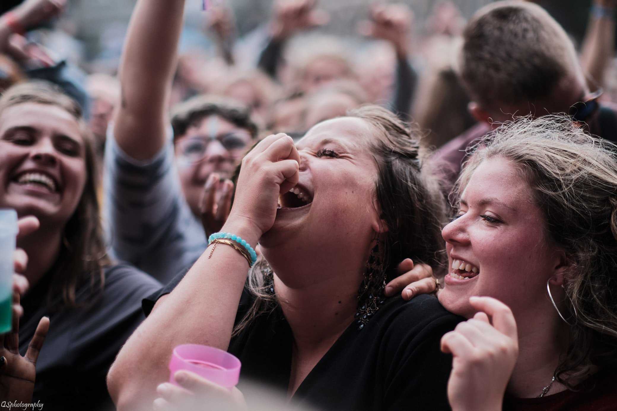 Un groupe de jeunes personnes rient et sourient lors d'un événement, affichant de la joie et de la camaraderie.