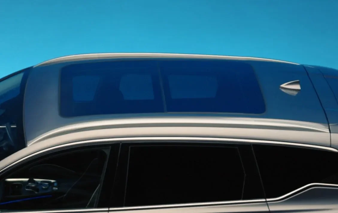 A modern car with a large sunroof against a clear blue sky.