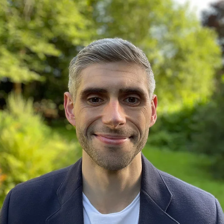Graham Hadaway of Hargreaves, wearing a navy blazer and white shirt, standing outdoors with green trees in the background.