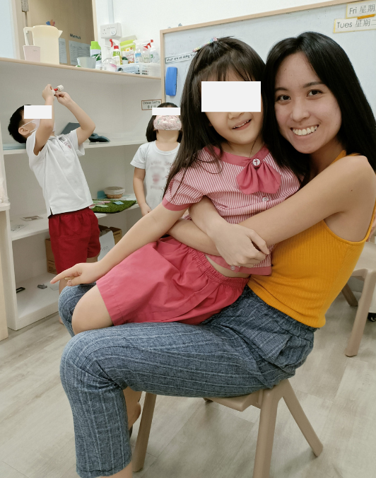 Hermes Lu sharing a warm moment with a child while other children play in the background.