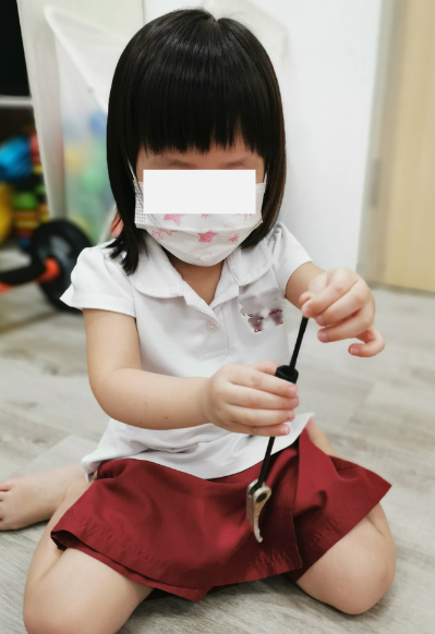 Young child exploring the weight and movement of a bicycle component.