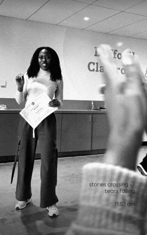 A woman holding a certificate, smiling, at an indoor event. In the foreground, a person's hand is raised. The background has a wall with partially visible text and a ceiling with fluorescent lights. The image includes a caption: 'stories crossing ♥ tears falling 11:53 am.'