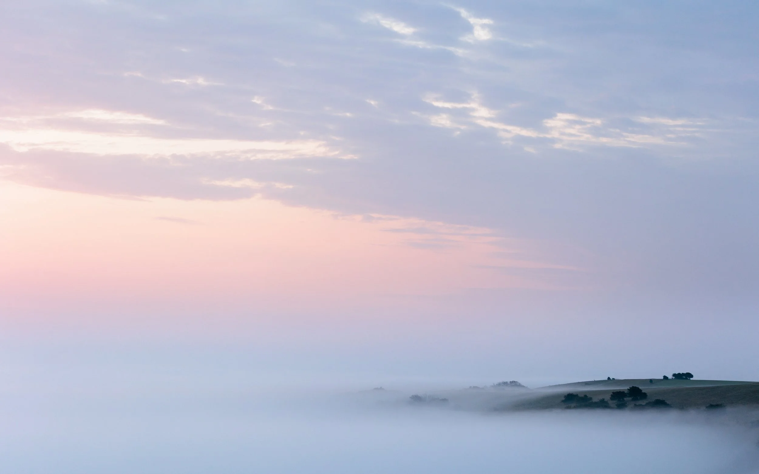 The top of Ditchling Beacon peaks out of the mist of a cloud inversion during sunrise
