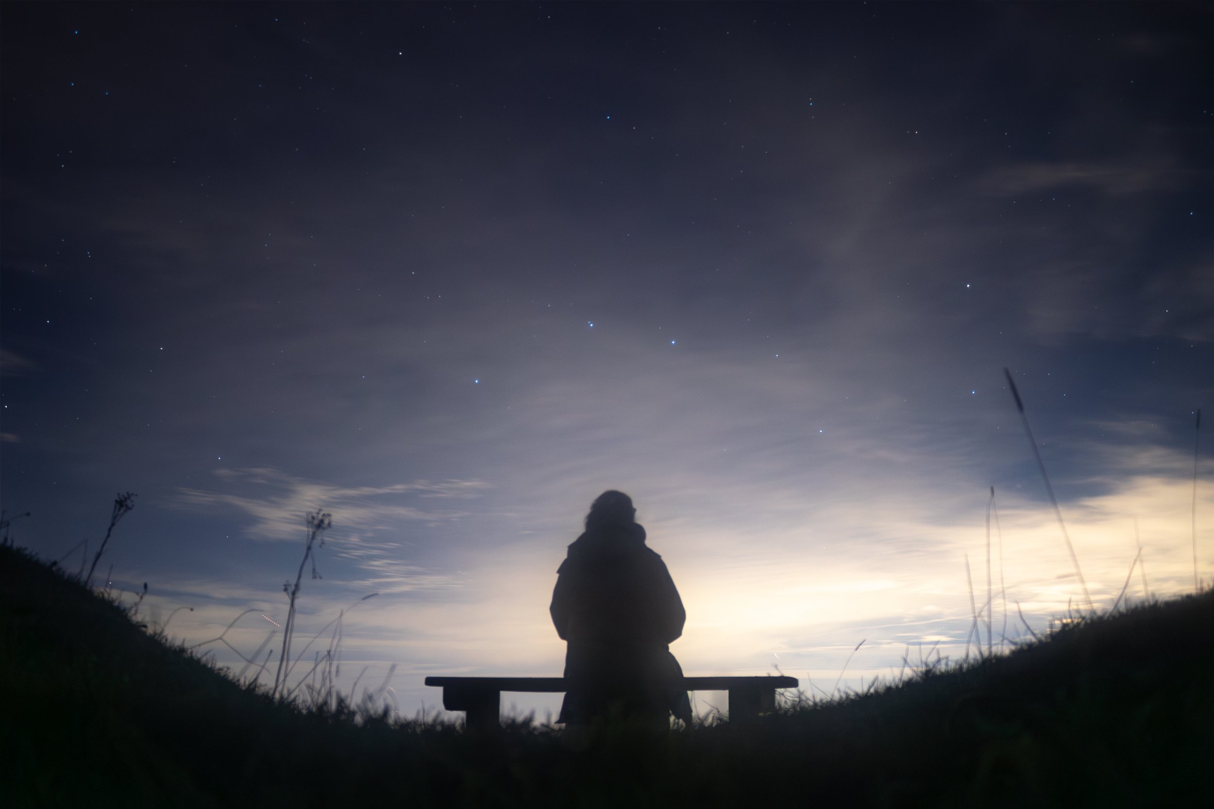 Highly commended, South Downs National Park Stargazer, Astrophotography competition 2026, a figure sits on a bench gazing out at the starry sky below the plough constellation