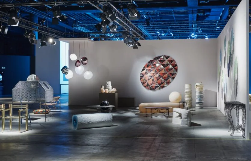 An art gallery with contemporary furniture and sculptures displayed on a modern, spacious floor with lighting and decorations.