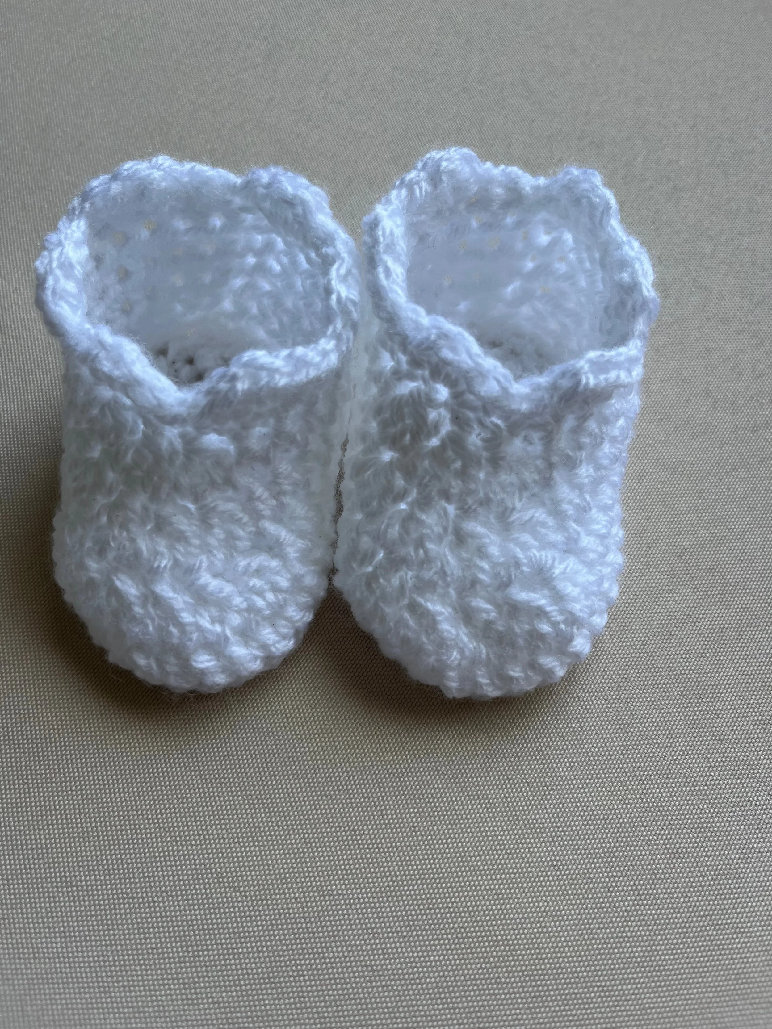 Handmade baby booties in white soft acrylic yarn by Tidestitch.jpg