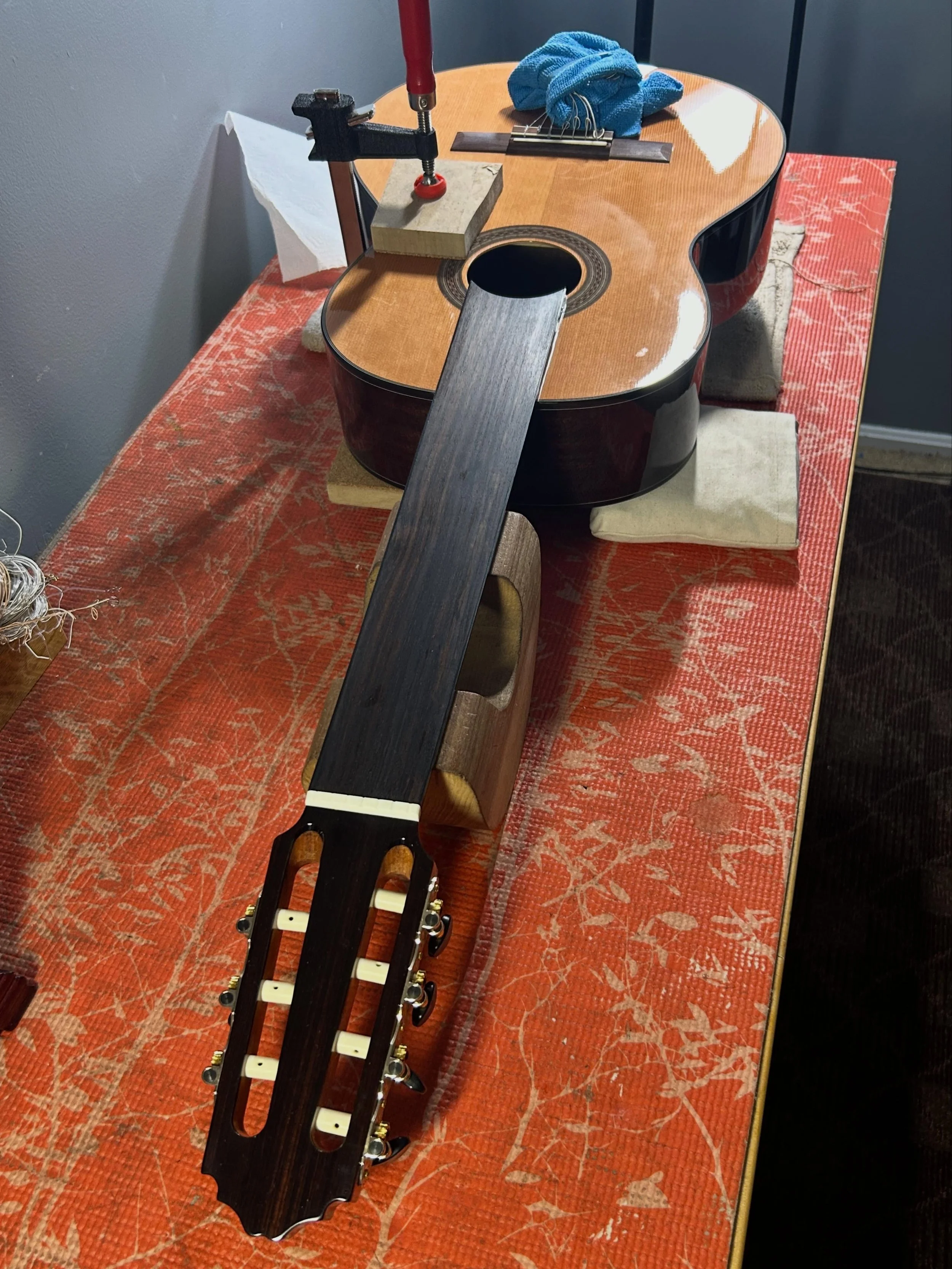 Brace reglue in a 7-string fretless classical guitar.
