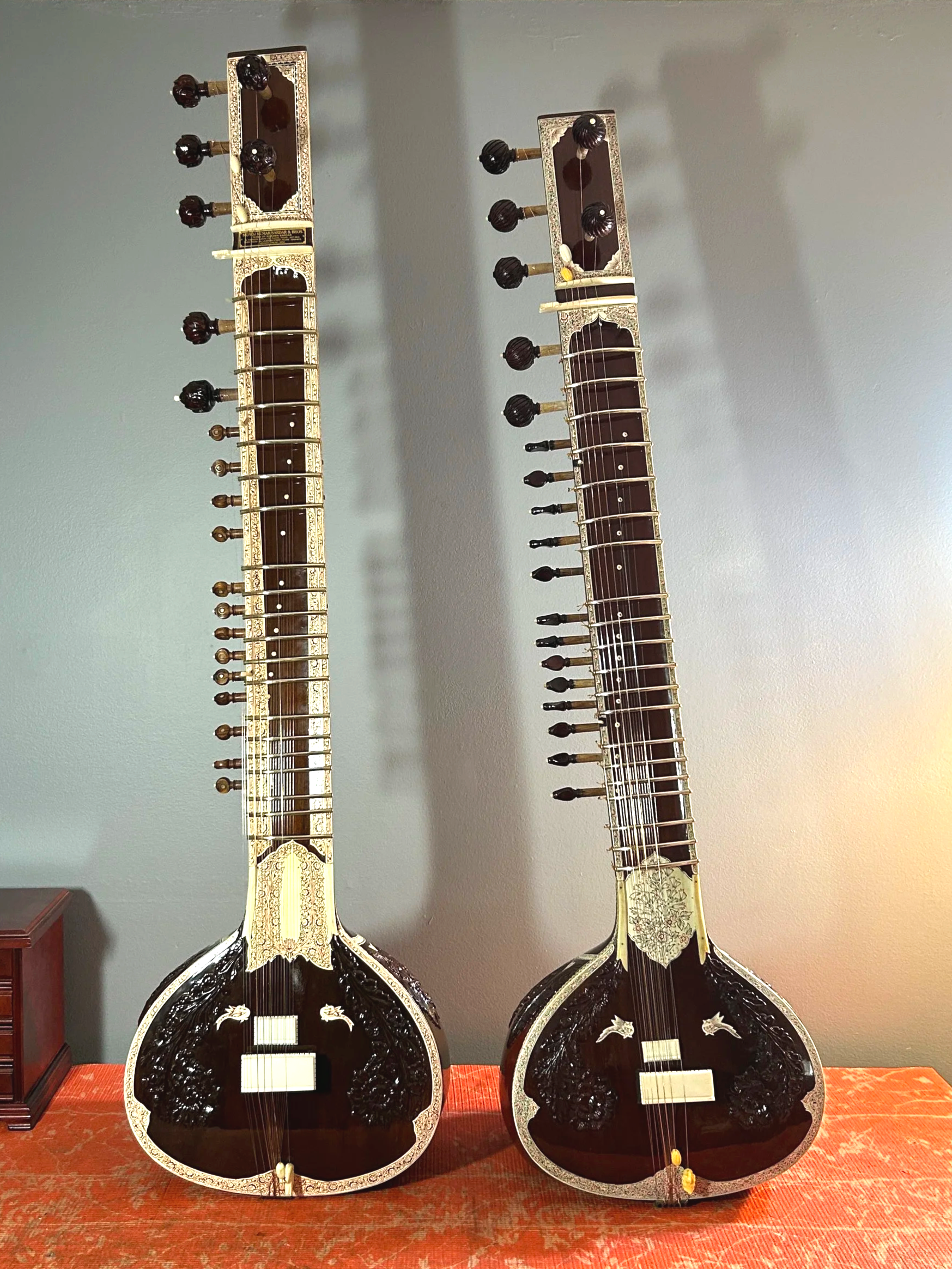 Two sitars propped up standing on a table.