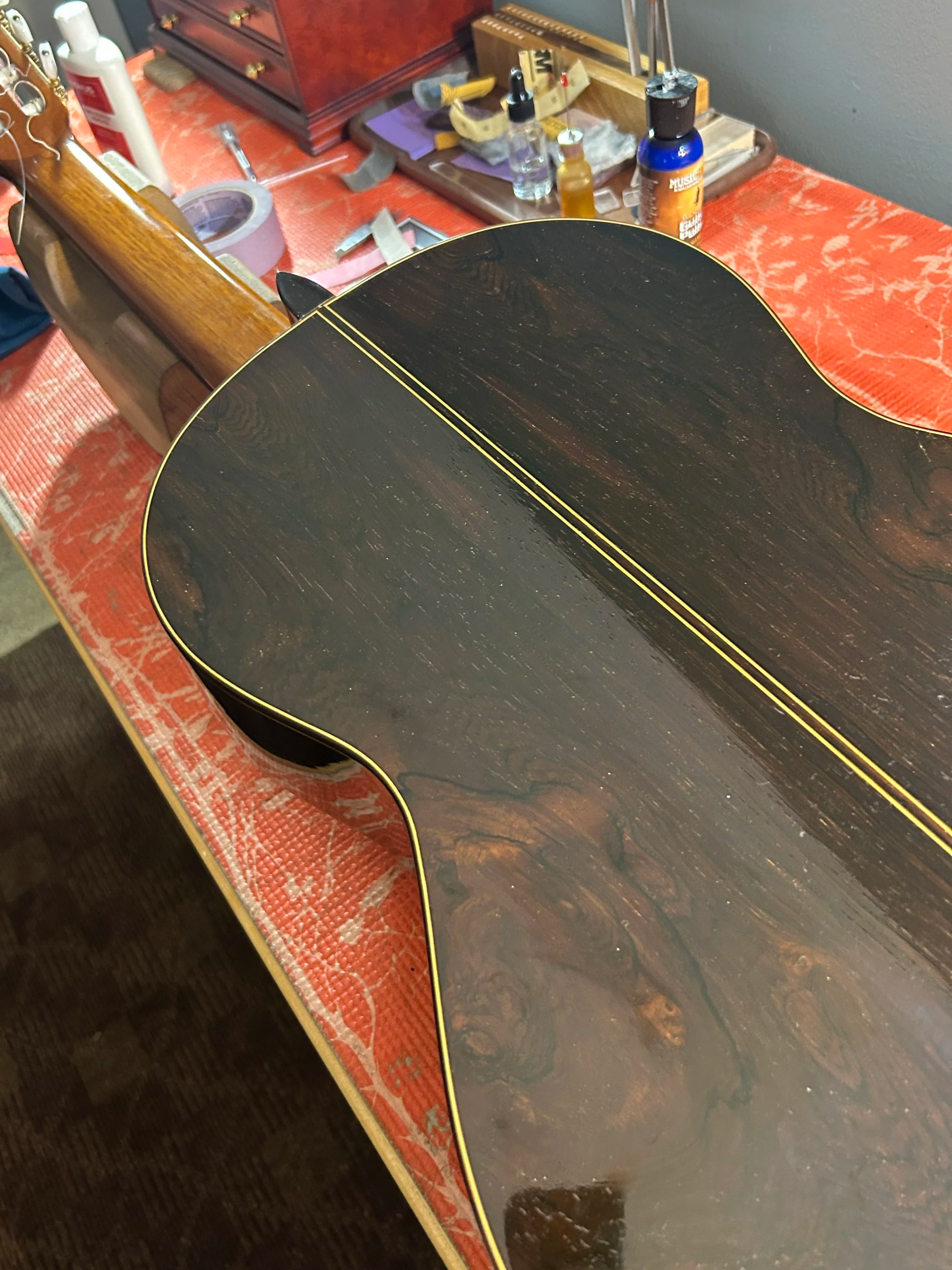 Back of a guitar on a work table after a back crack repair.