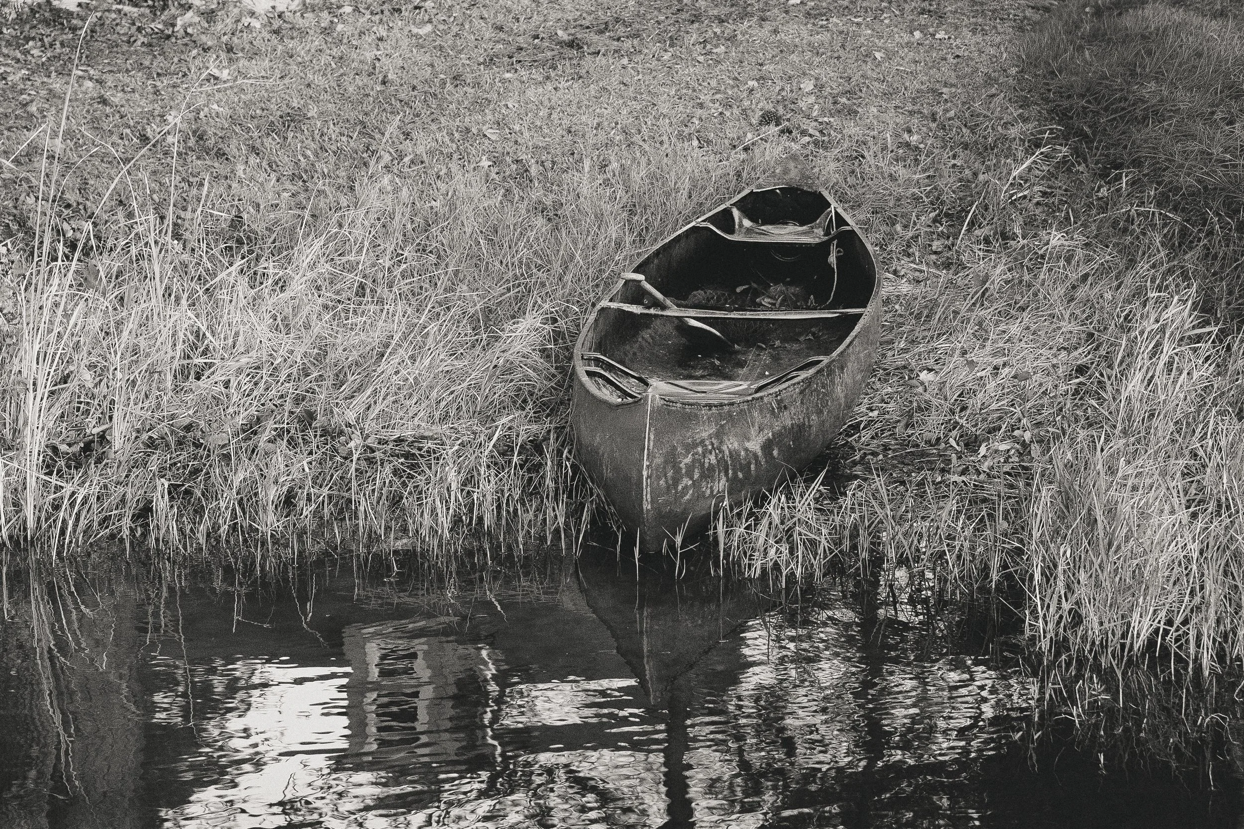 canoe resting side of quiet lake.jpg