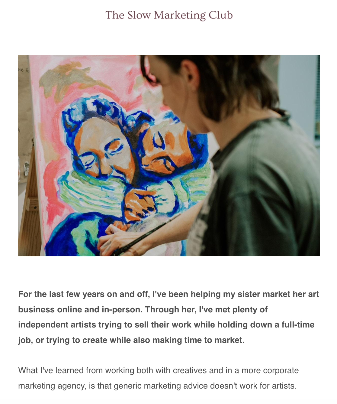 A woman is painting a colorful portrait of a boy and a dog on a canvas, with her head turned to the side in a studio or art space.