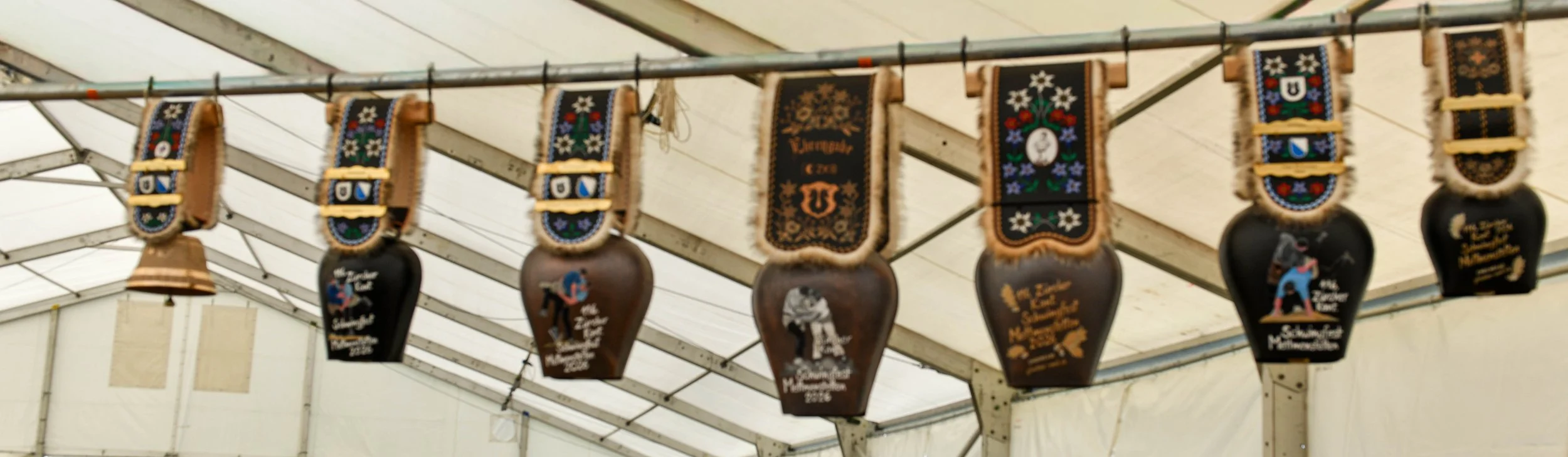 Bierkrüge und Fahnen mit traditionellen Mustern in einem Festzelt.