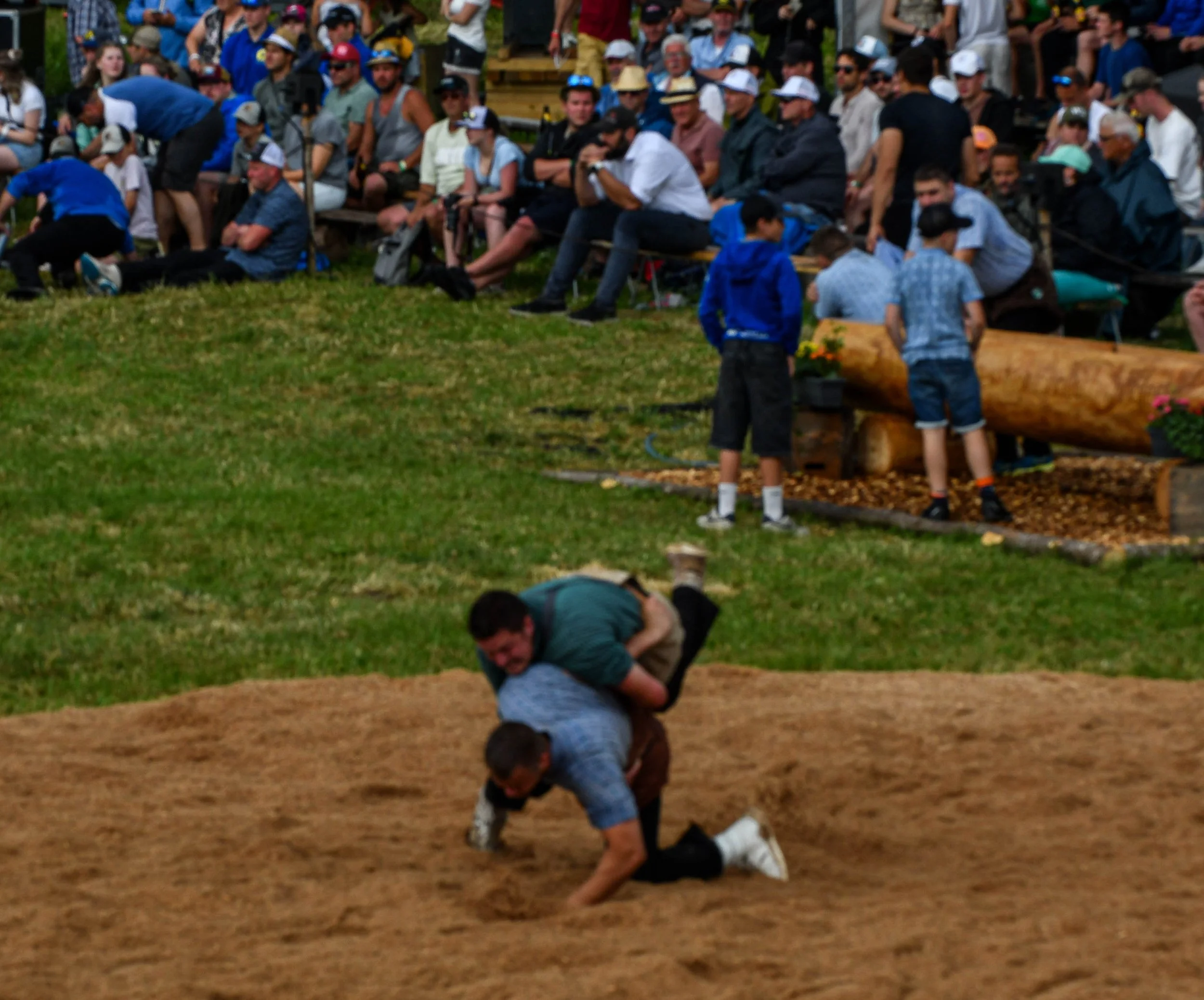 Menschen beim Wettkampf im Ringen auf einem Rasen im Freien.