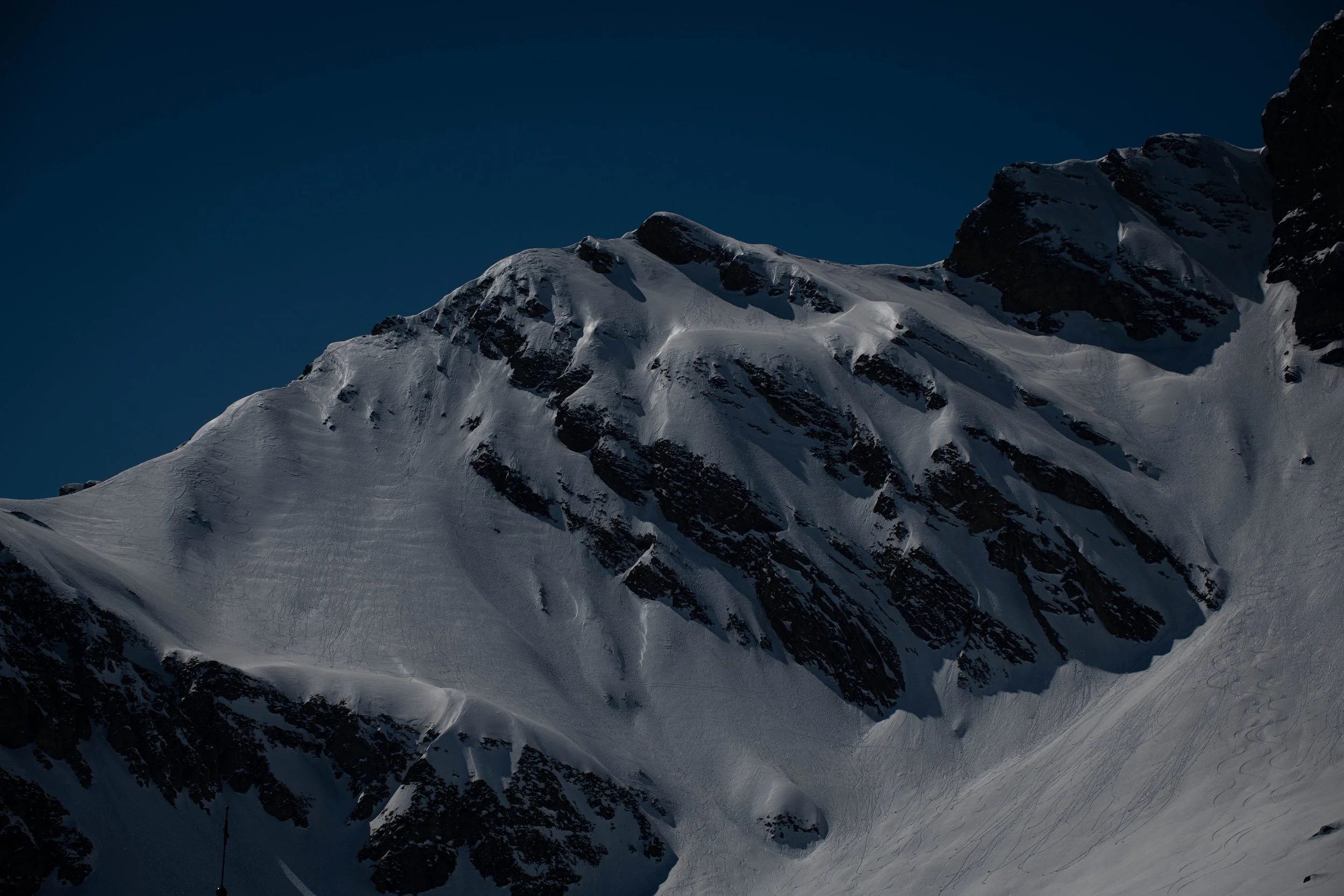 Schneebedeckte Berggipfel bei Nacht, dunkler Himmel