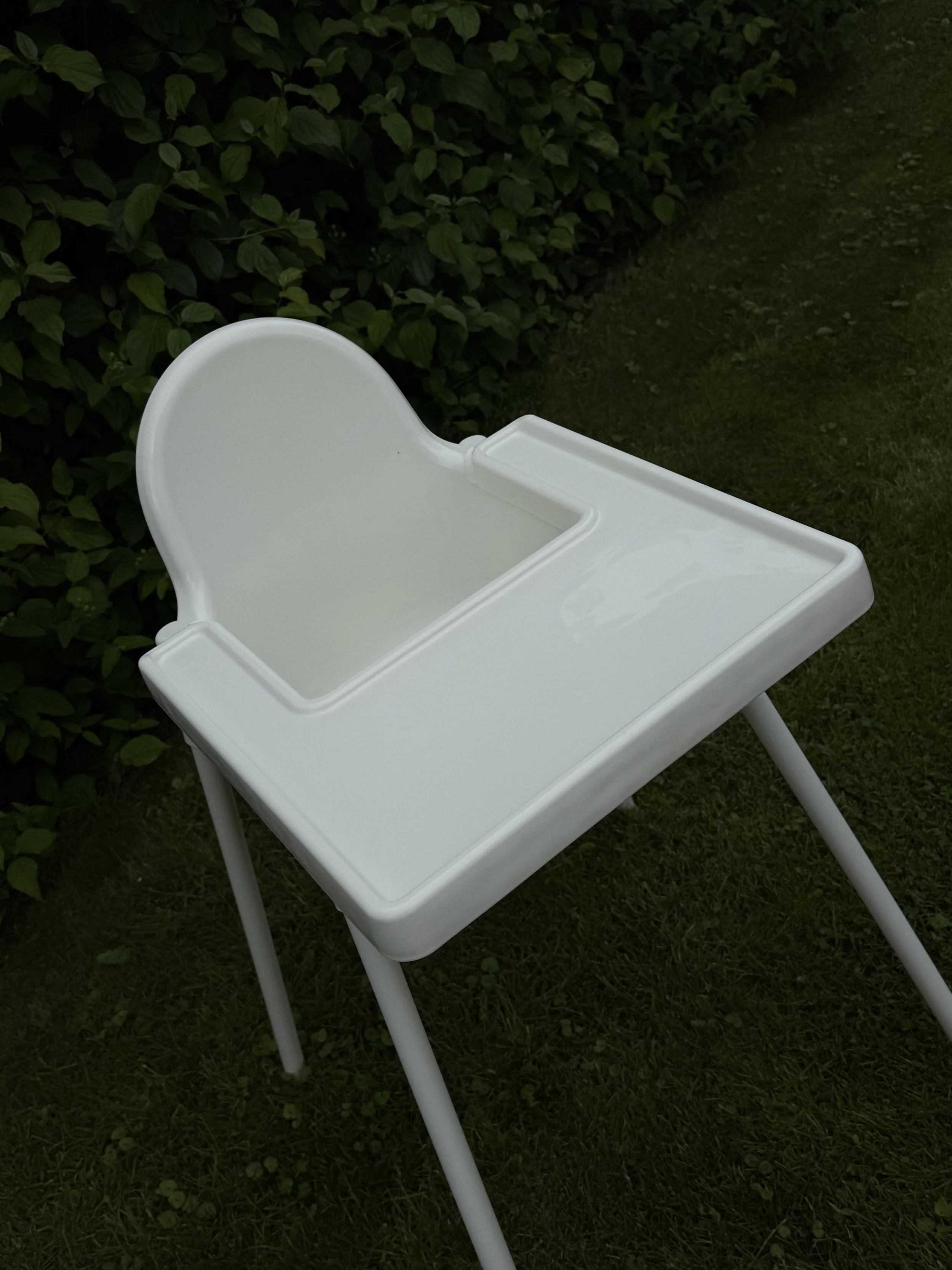 Weißer Kinderhochstuhl Positano mit Sicherheitsgurt und abnehmbarem Tablet für kleine Gäste bei Hochzeiten und Veranstaltungen.