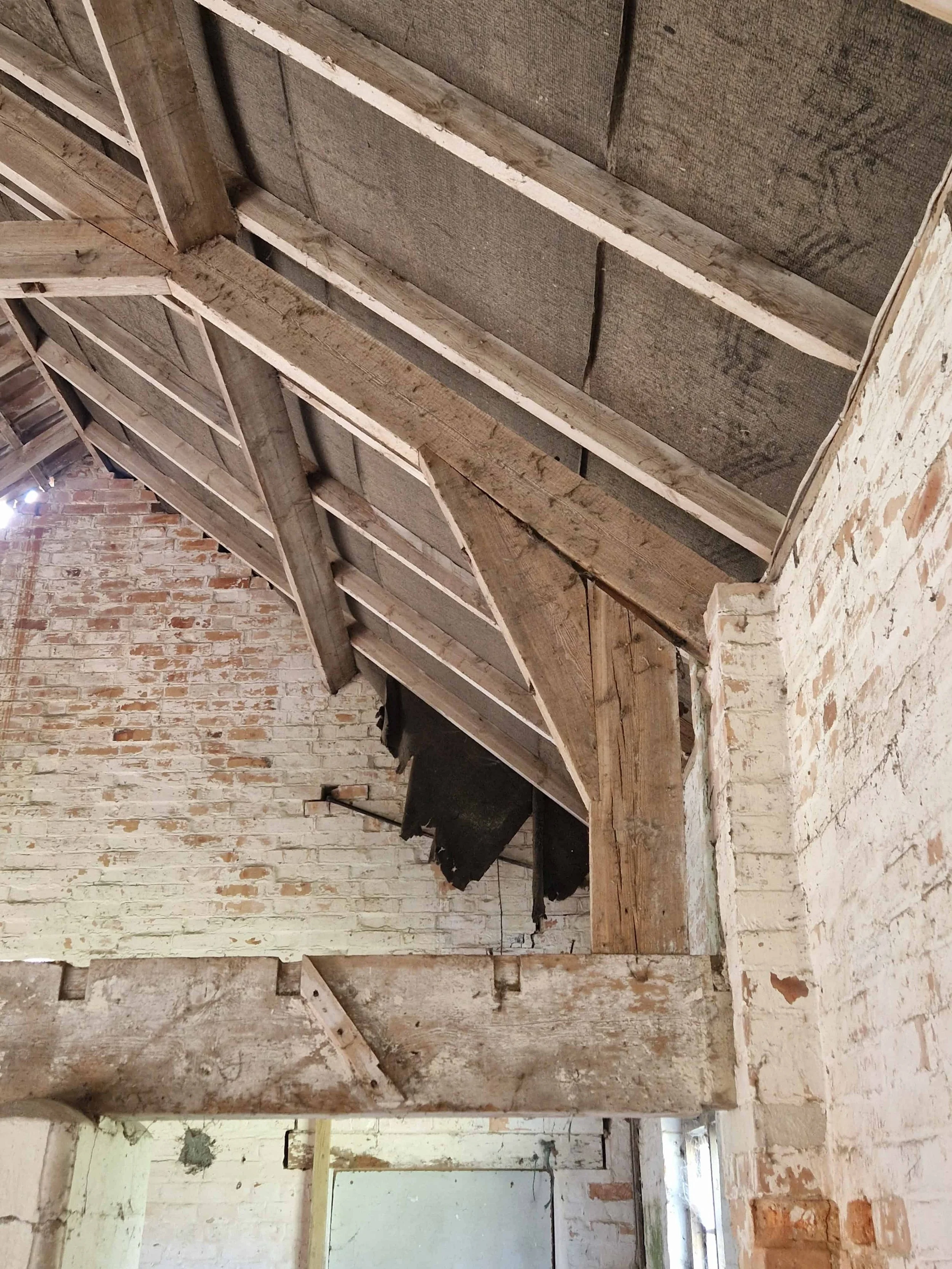 Old traditional timber truss joints with exposed wooden beams and vaulted ceilings.
