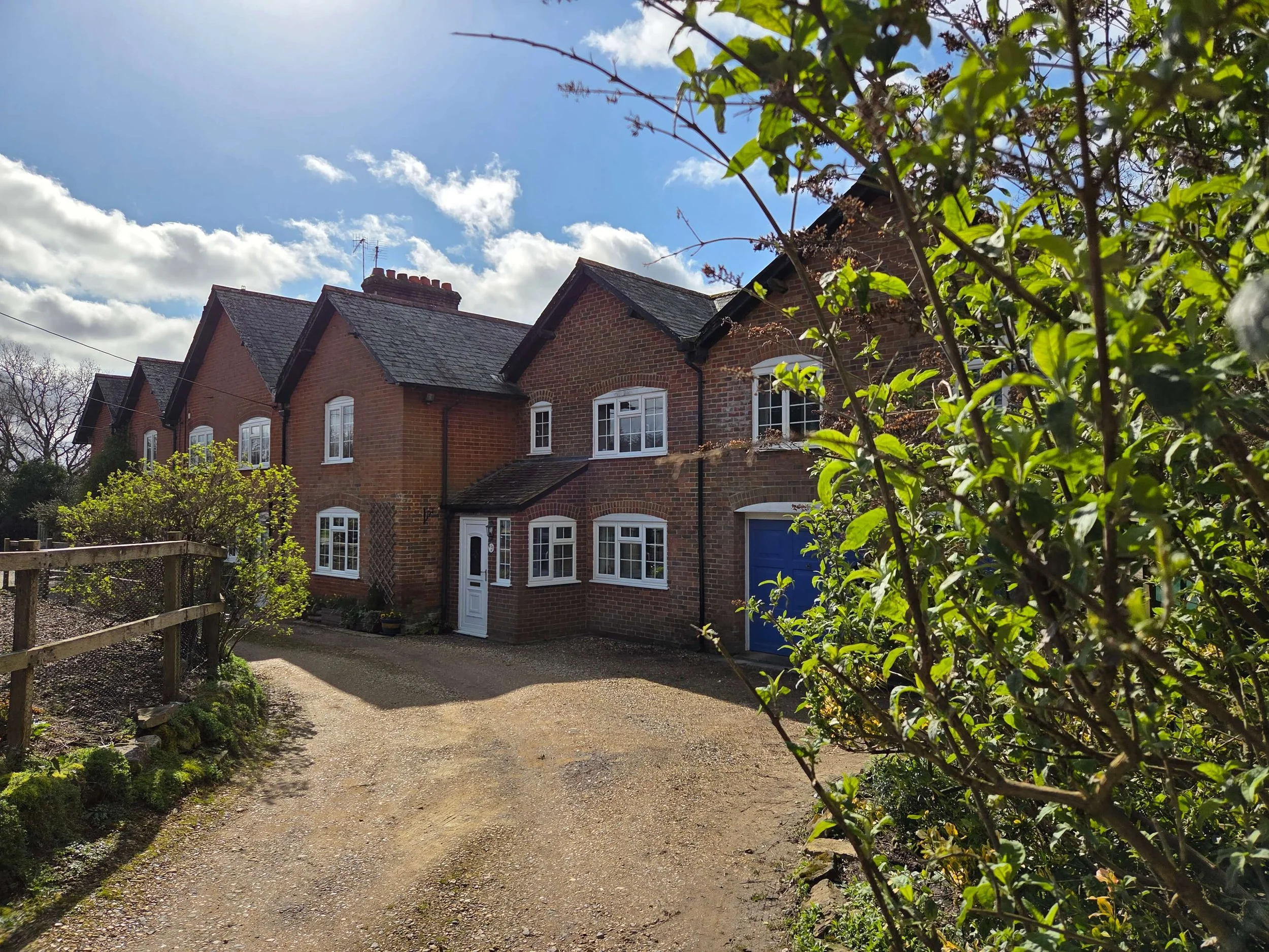 A 6 bedroom red brick country house with white casement windows, traditional chimneys, slate roof and driveway. Extension and internal architectural alterations, new kitchens and new bathrooms.