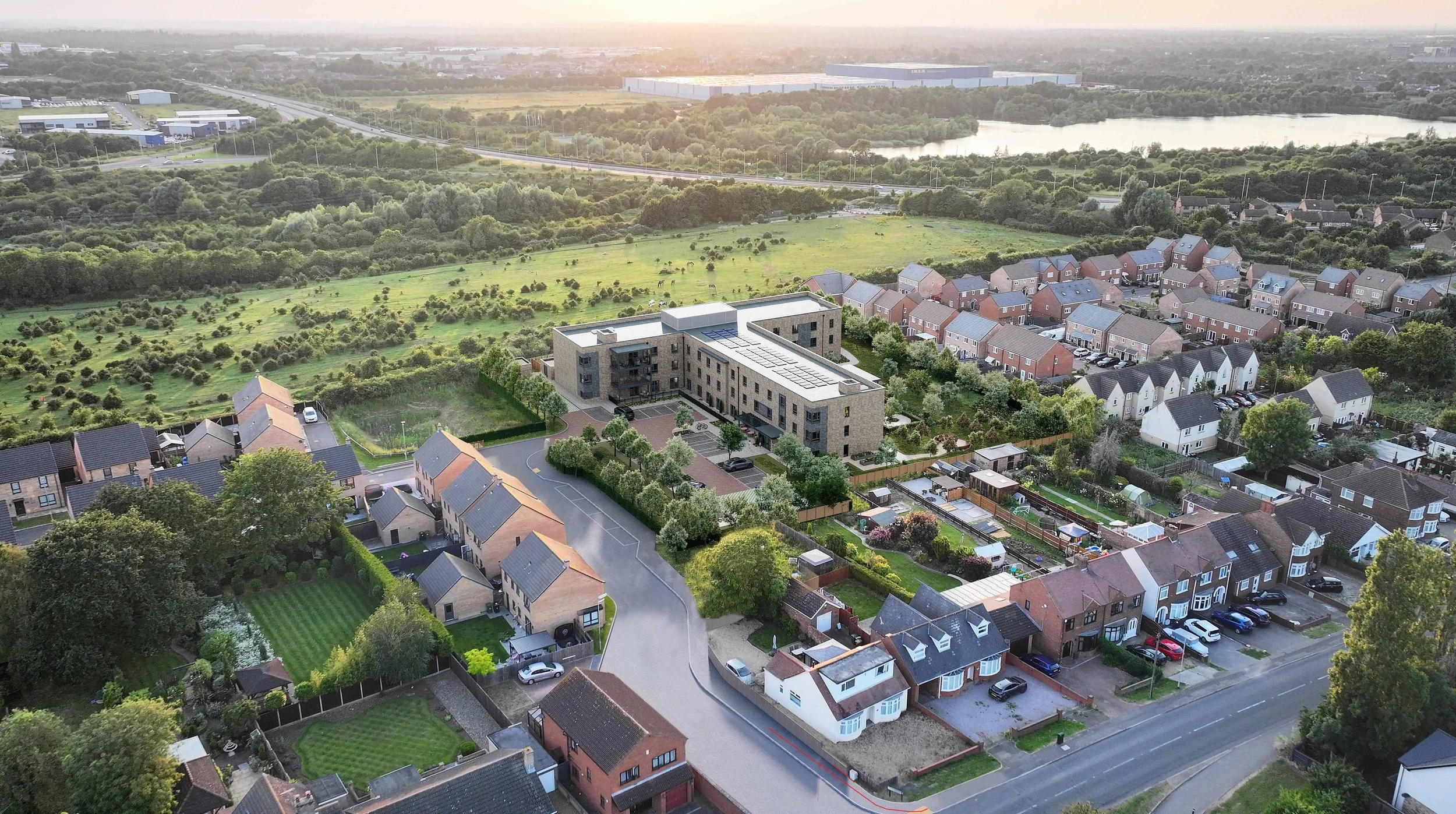 CGI design aerial view of a suburban neighbourhood with rows of houses, a new build 80 bedroom brick care home building, green lawns, trees, a park area. Roads and a highway are visible in the background during sunset.