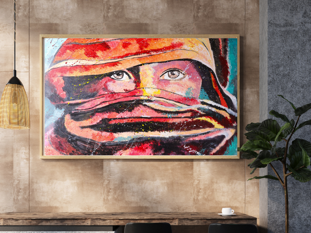 An abstract painting of a face with prominent eyes, using bold colors and expressive brushstrokes, framed on a wall in a modern interior space.