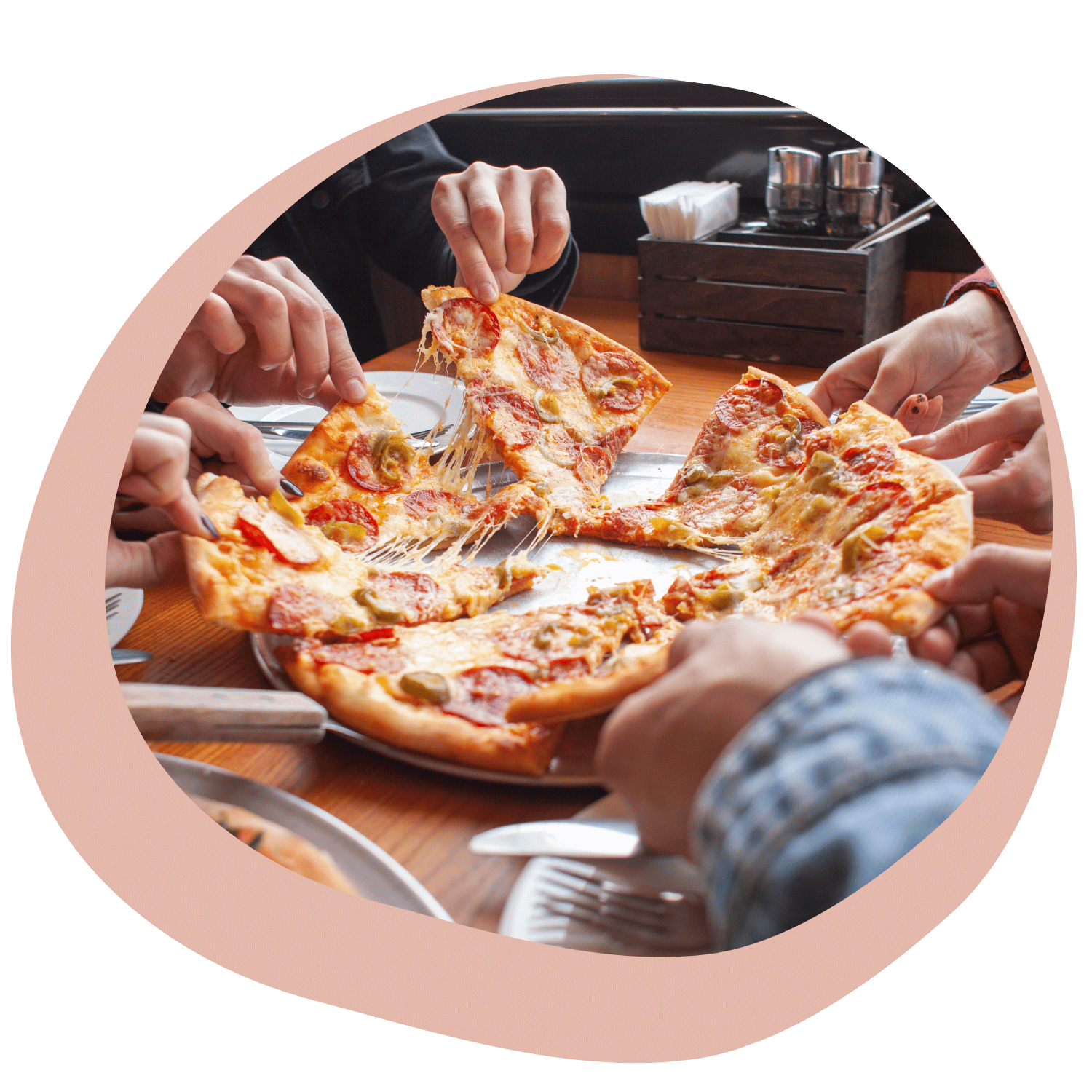 Folk som äter pizza tillsammans vid ett bord.