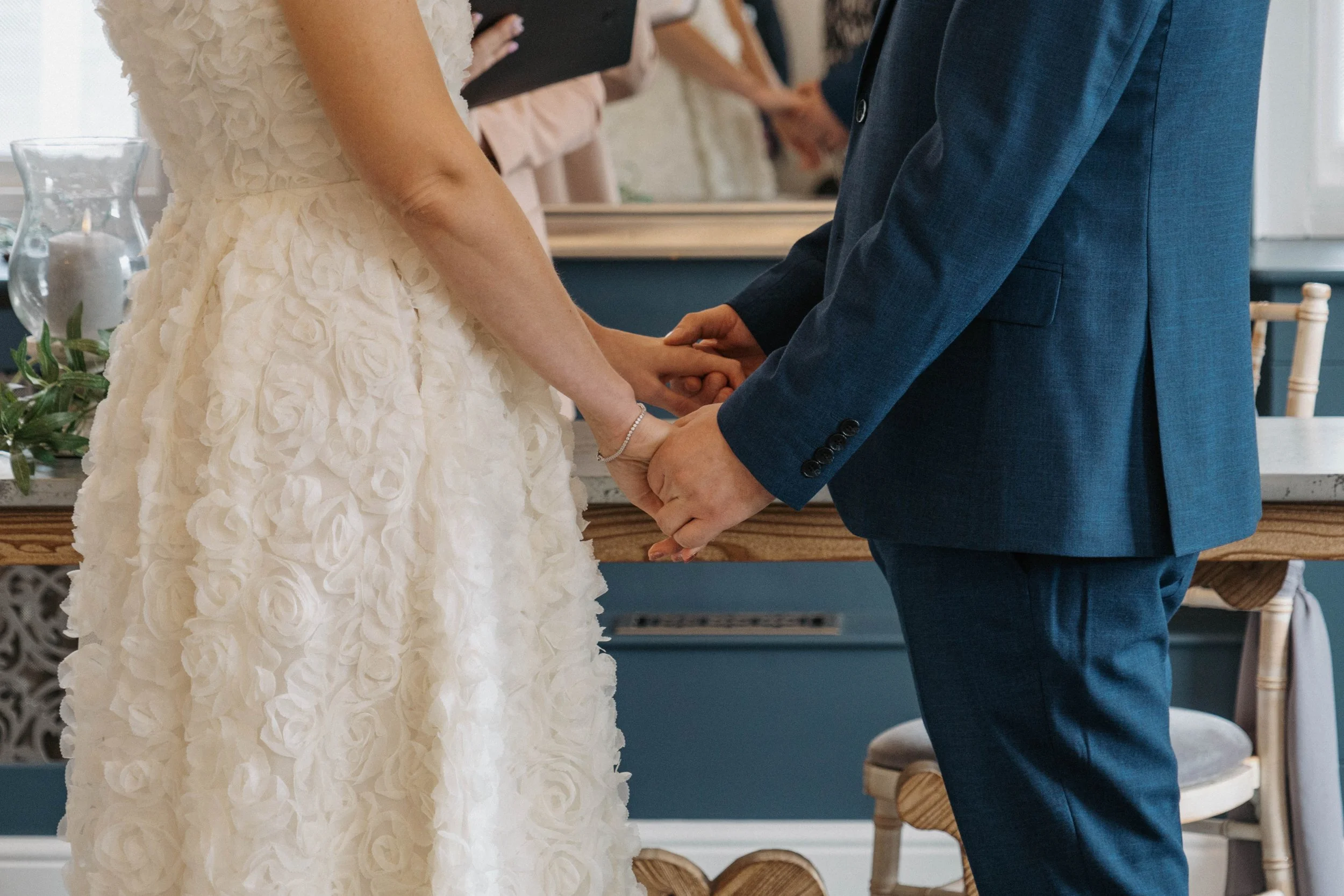 Bride and groom holding hands during their wedding ceremony.
