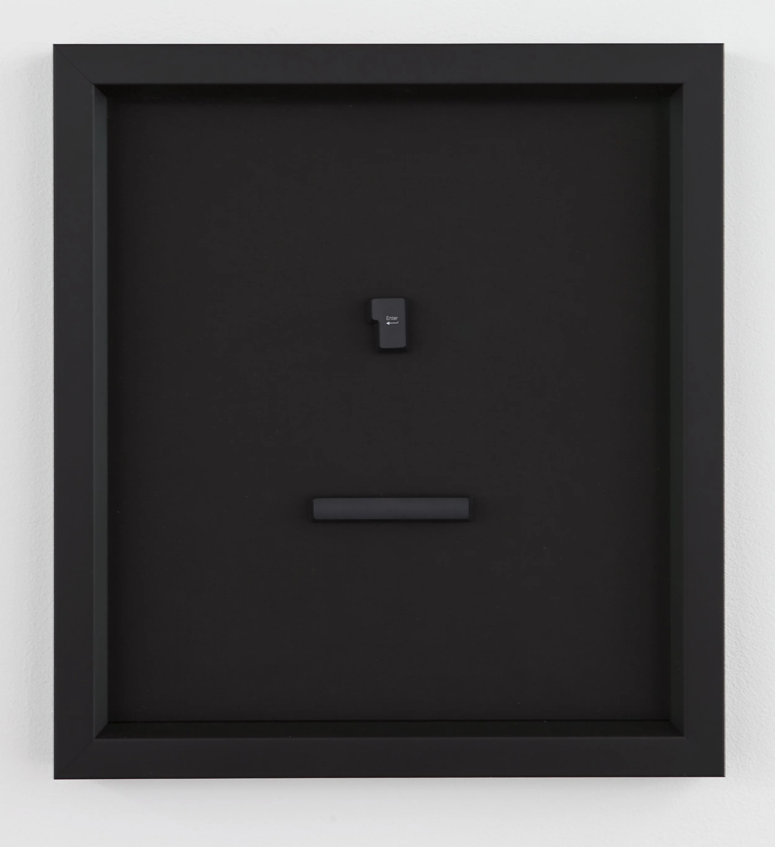 Black security safe with a small keypad and a handle, mounted on a white wall.