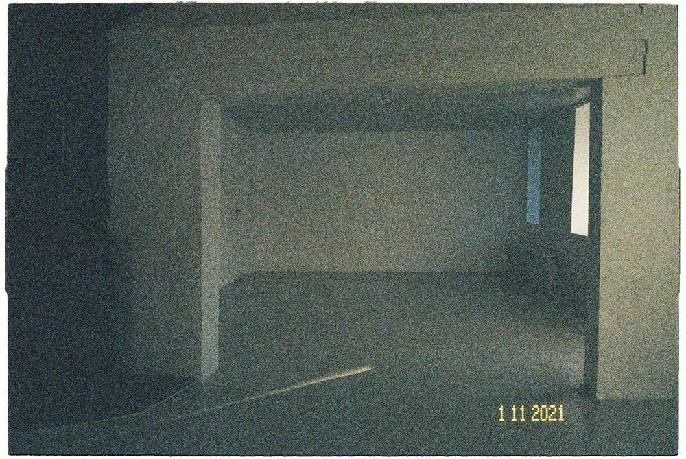 Empty room with a large opening leading to an adjoining space, with a small window on the right wall and dated 11/11/2021 in the bottom right corner. The gallery is Noplace (Oslo). Now closed.